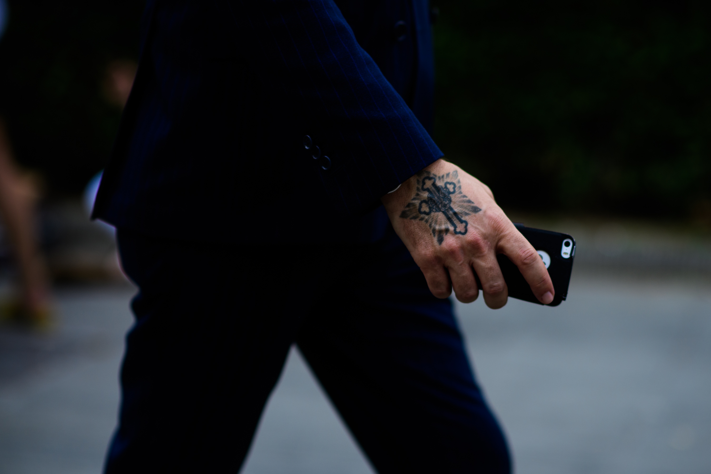 A tattoed hand of man in a suit