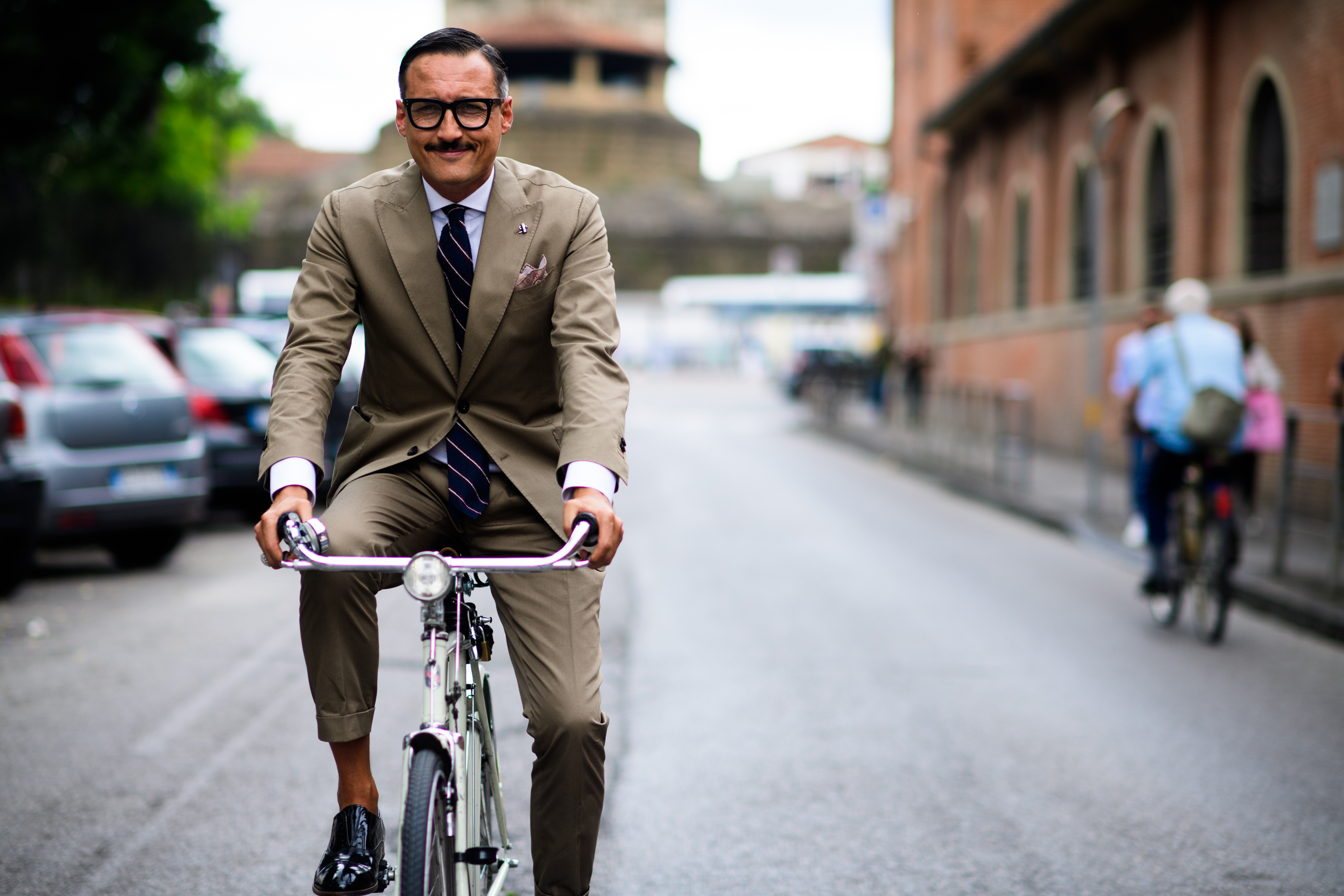 A man in a suit on a bicycle