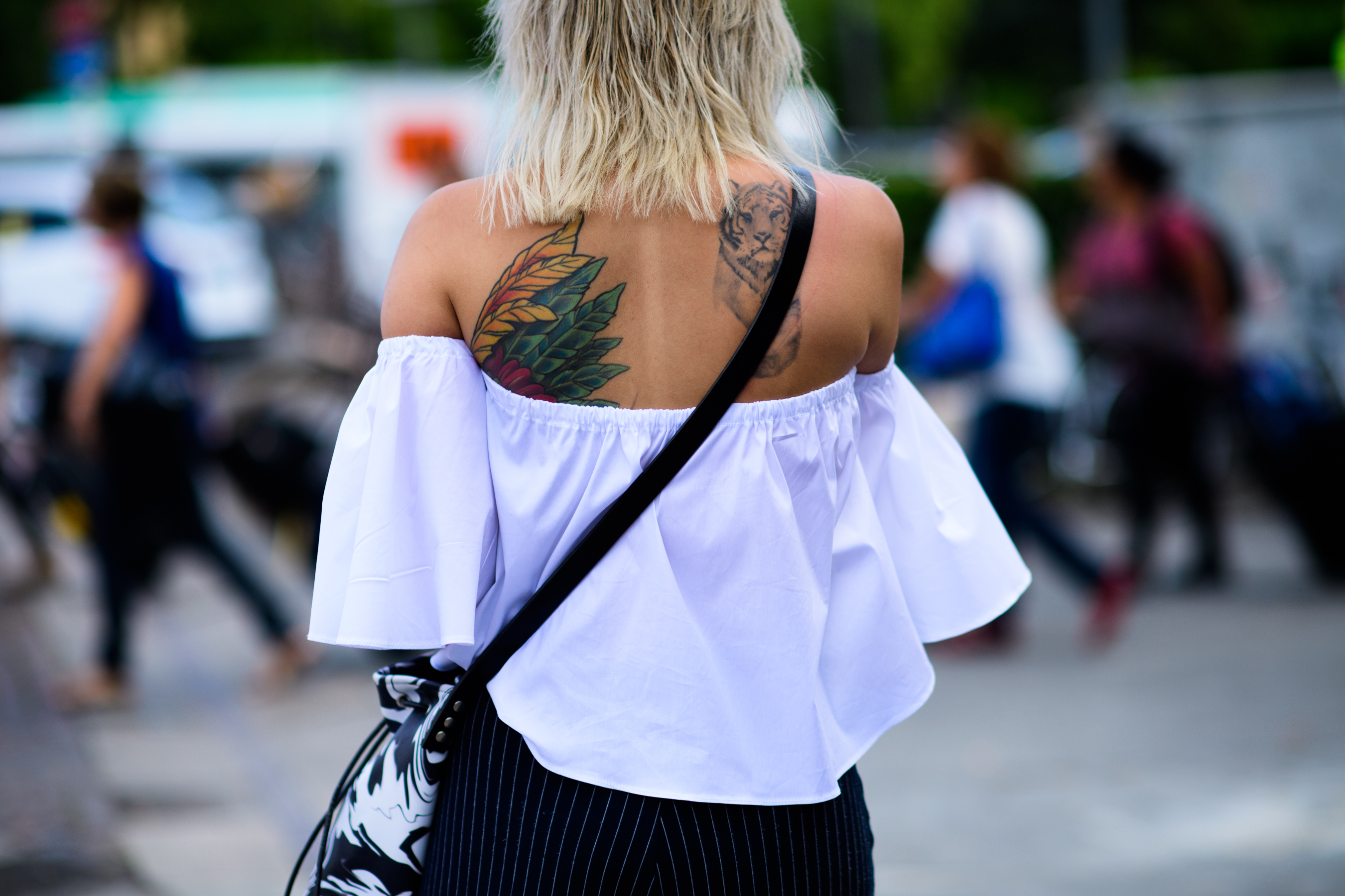 A tattooed girl in an off-shoulder top