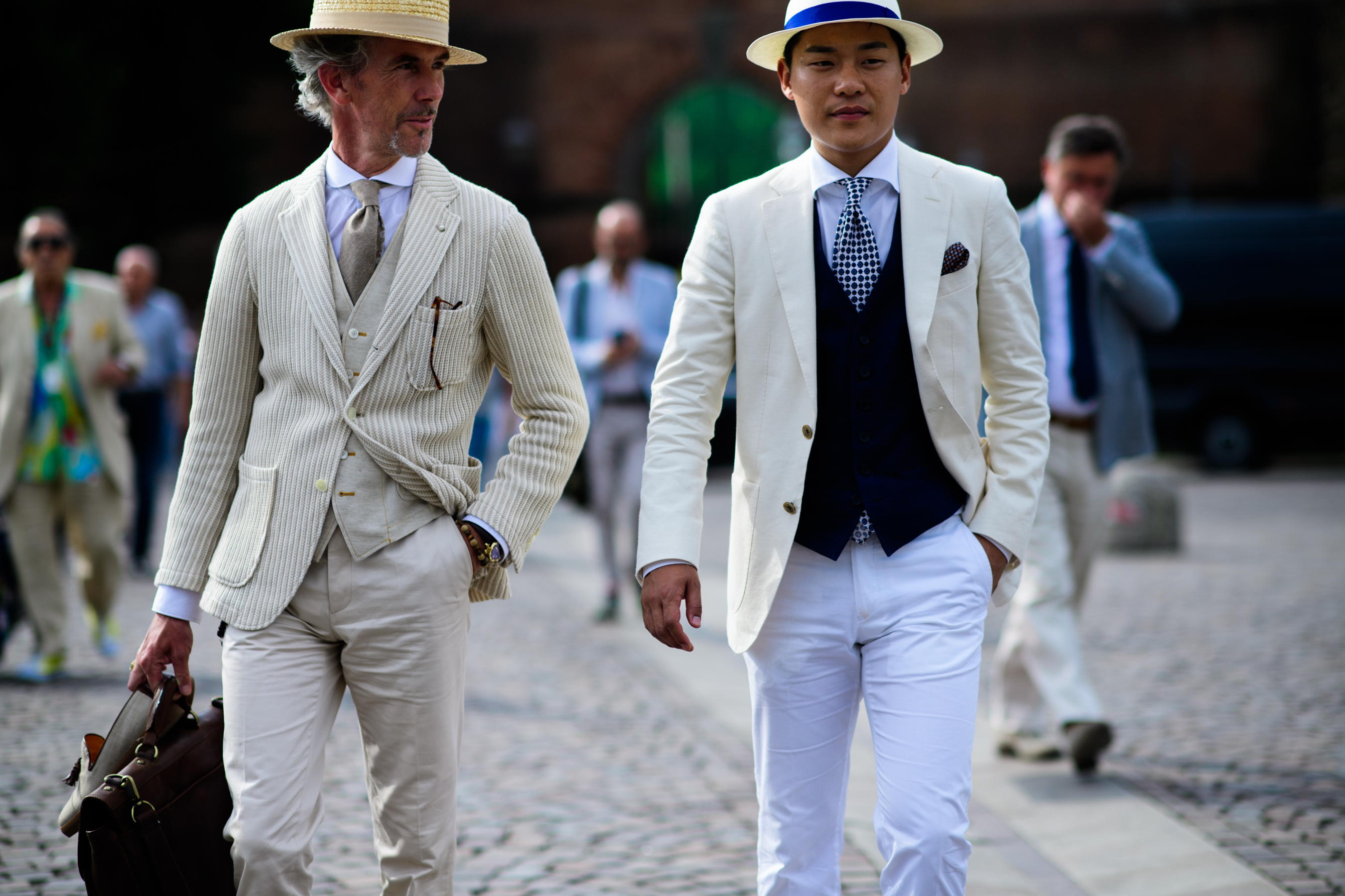 Two men wearing beige jackets and hats