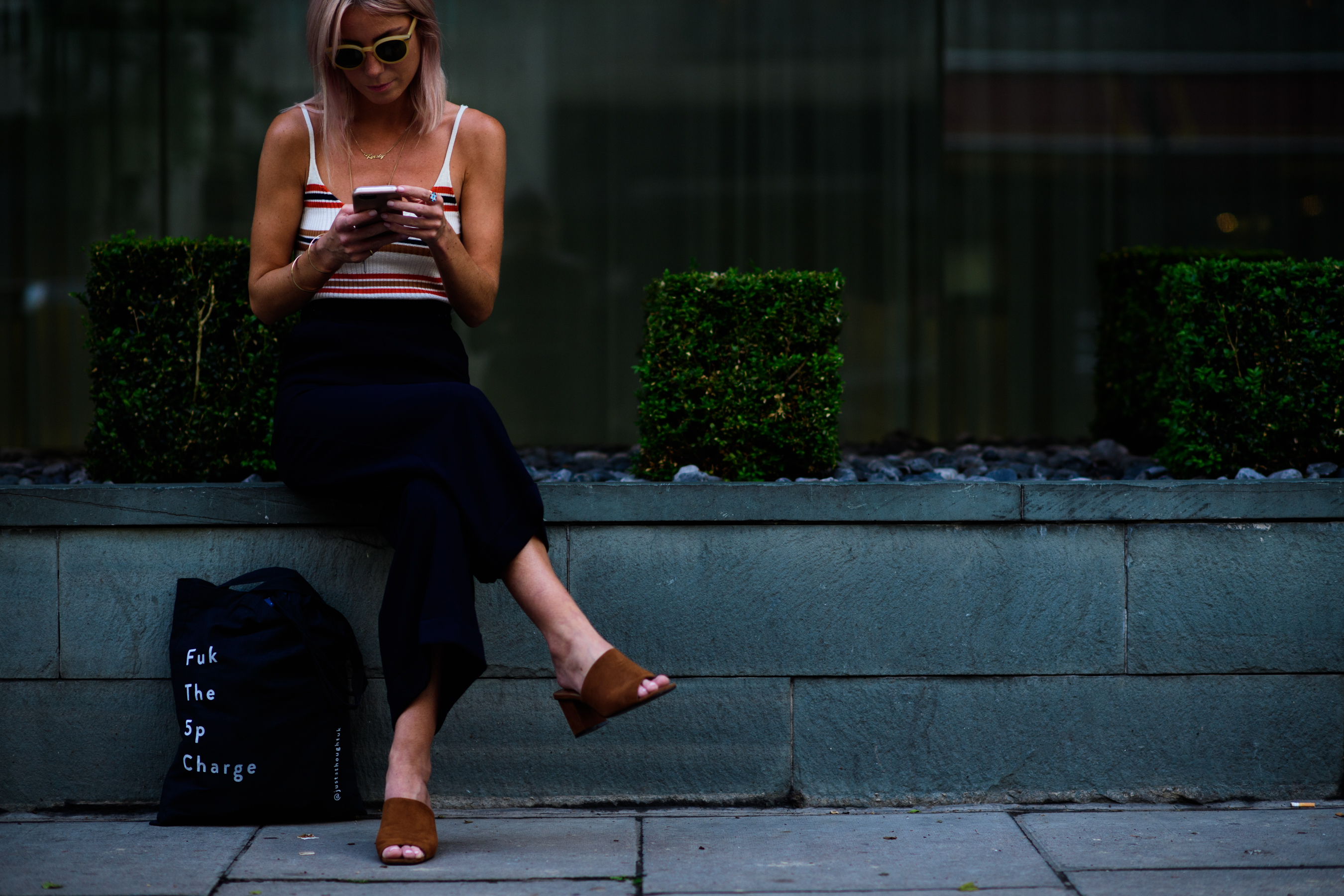 A woman wearing dark blue trousers, striped top