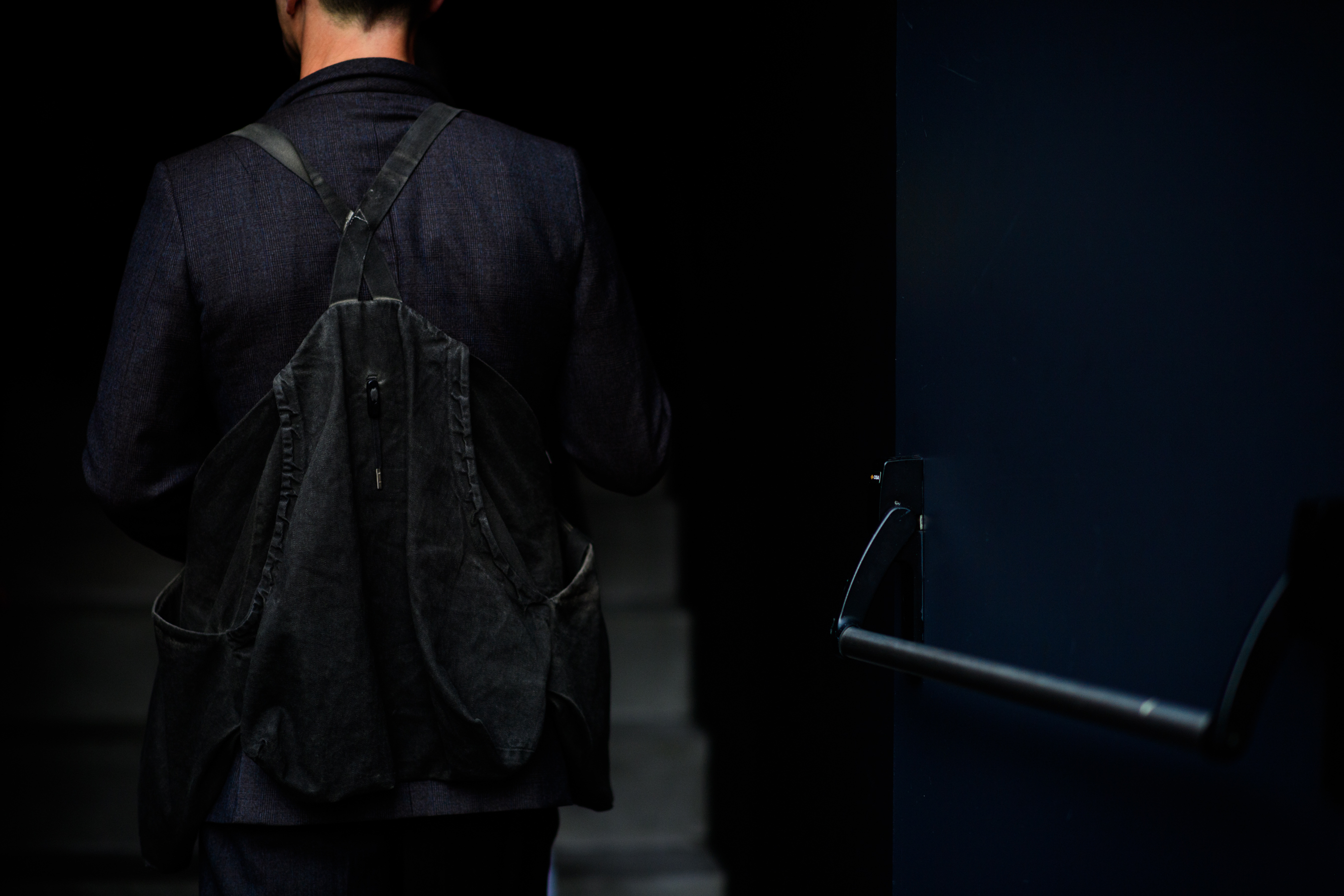 A man with a backpack in a suit