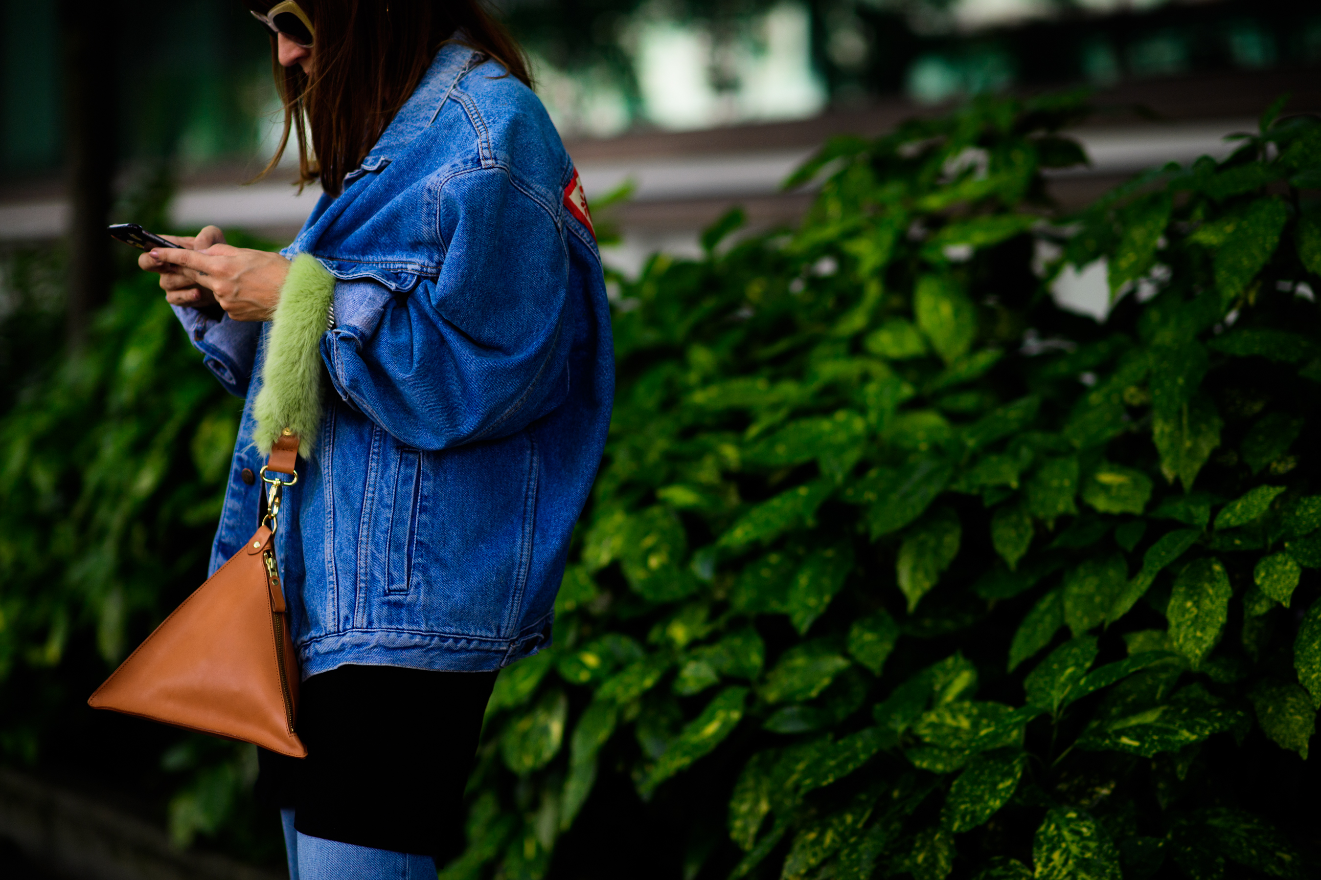 A woman in a denim jacket and sunglasses