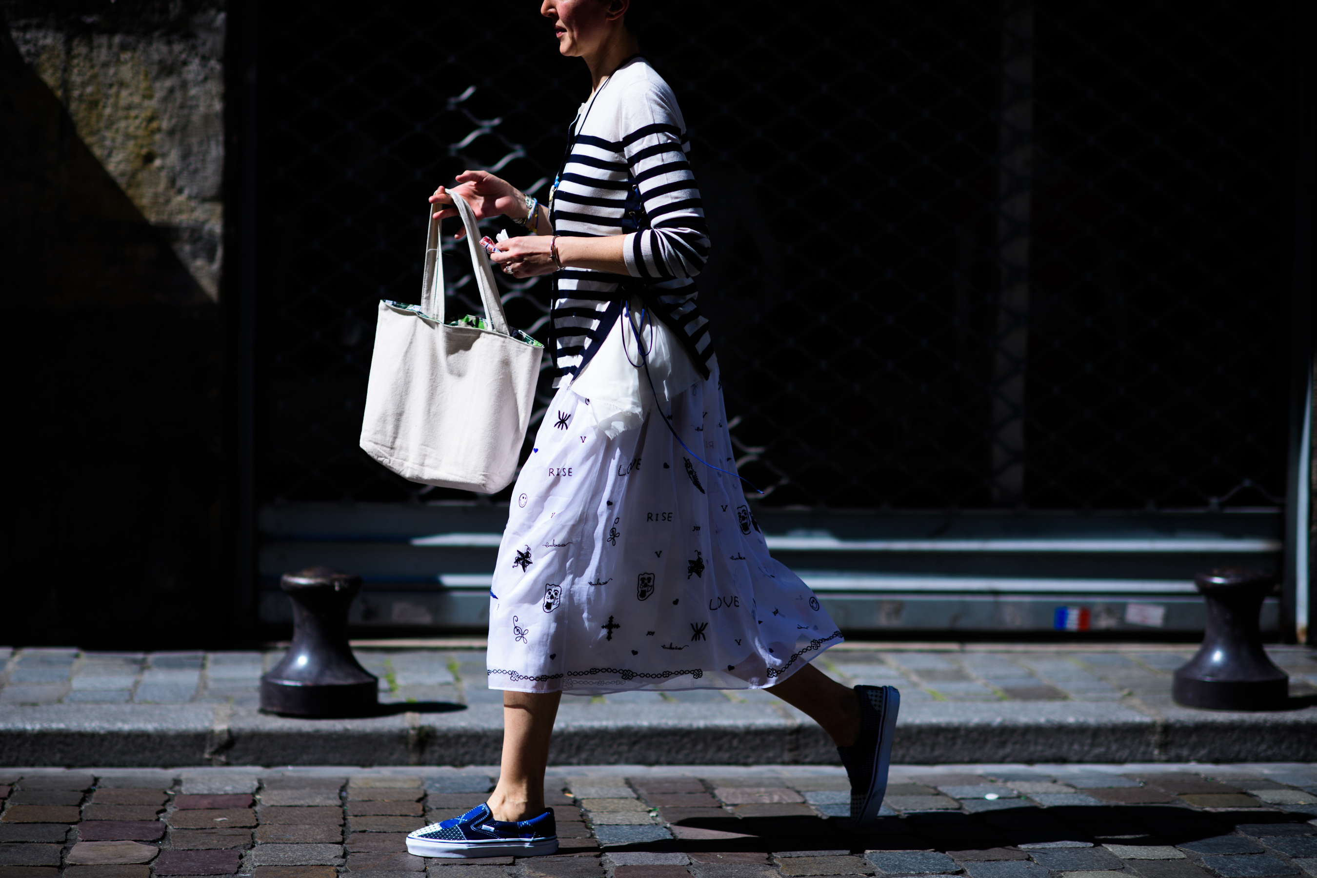 A woman in a midi skirt and blue shoes