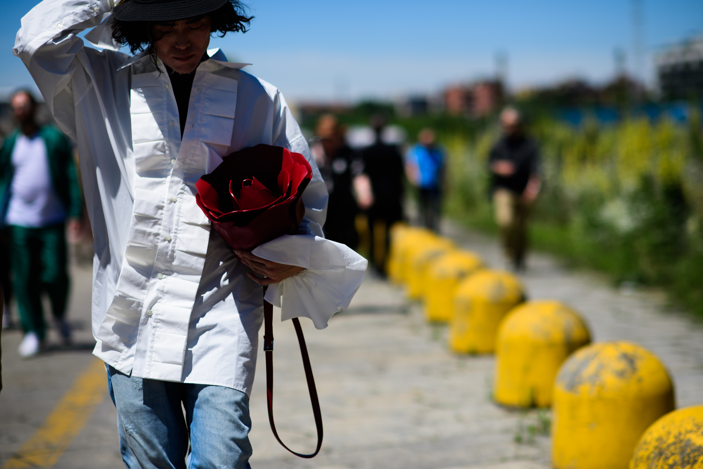 A woman in white with a red bag