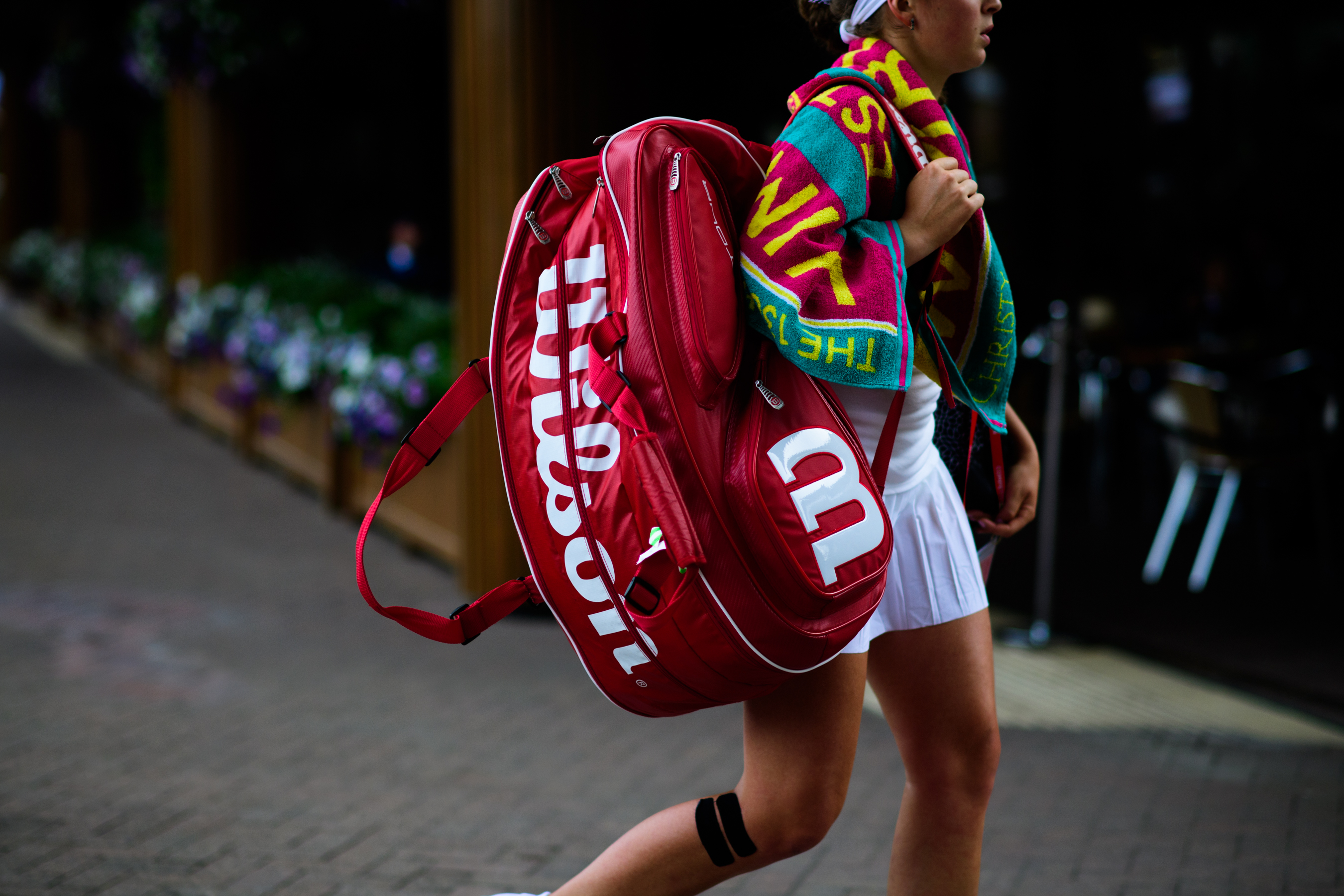 Woman carrying big red tennis bag