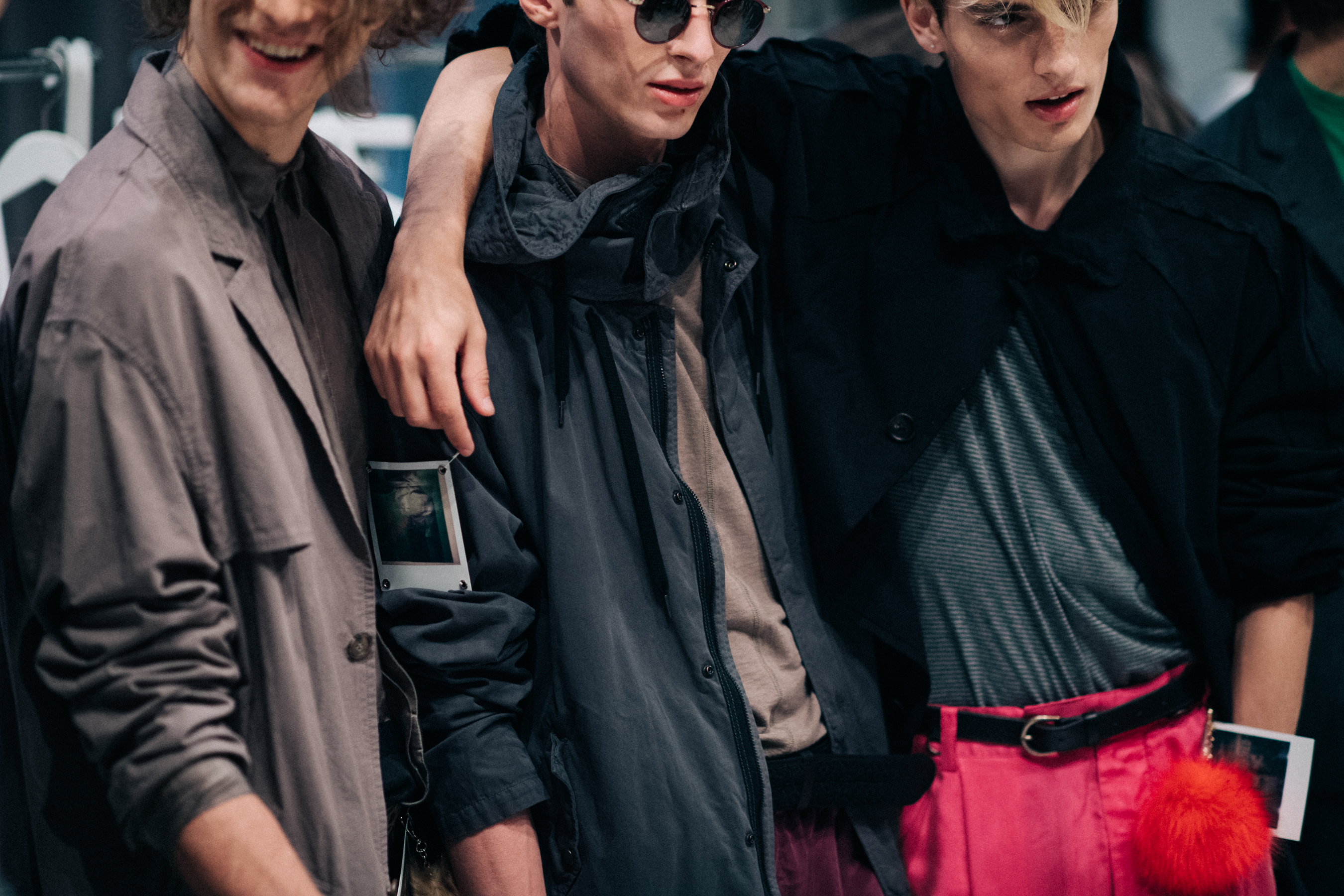 Three male models dressed before show