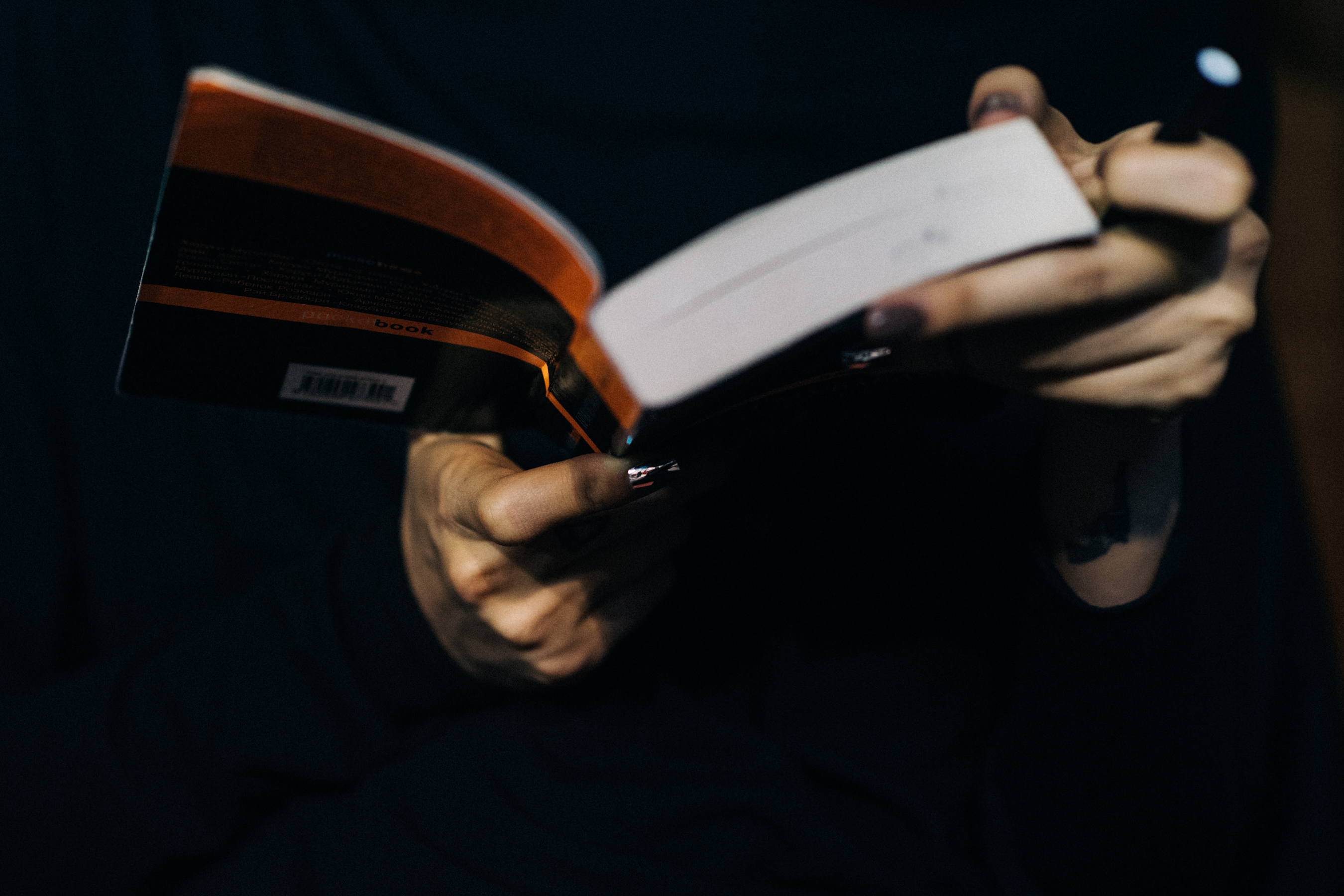 Model with silver nails reading book