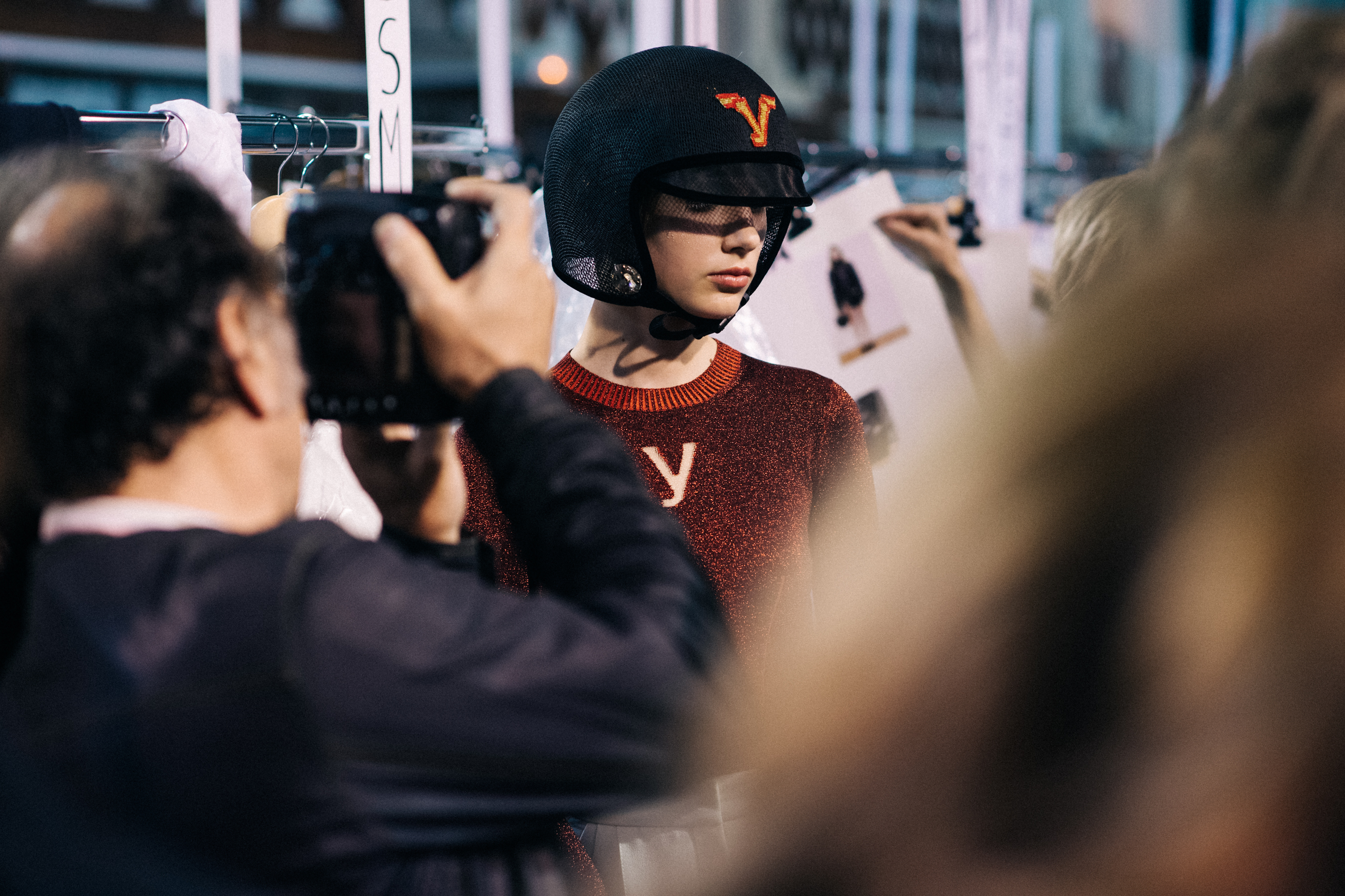 Model wearing helmet and red sweater