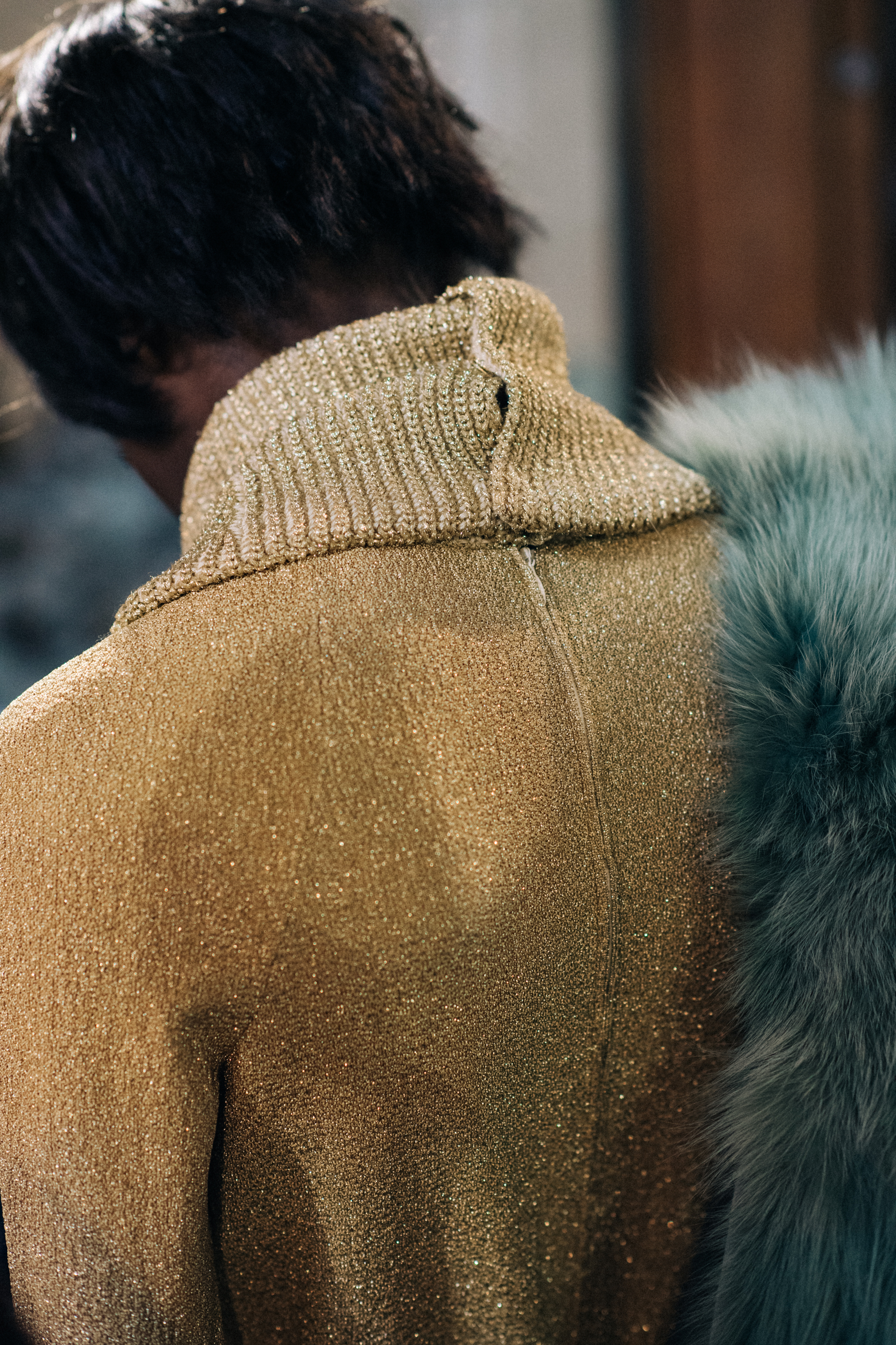 Model wearing golden jumpsuit and fur