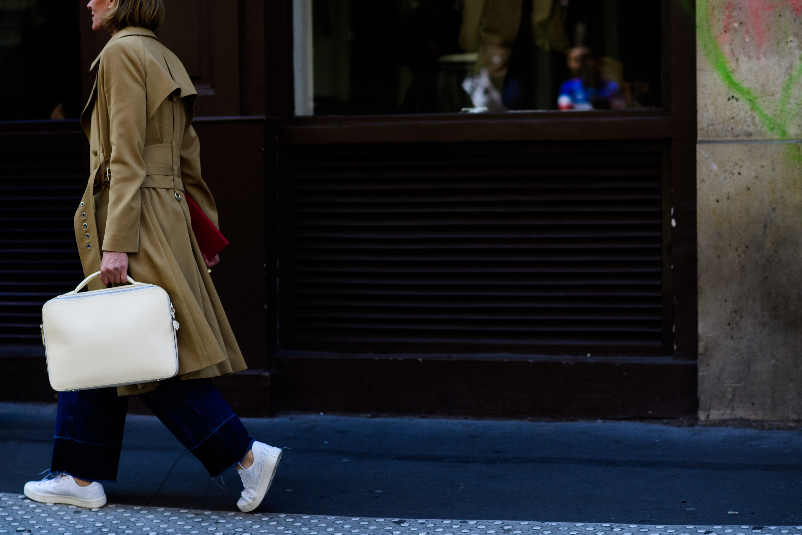 Woman wearing brown coat and sneakers