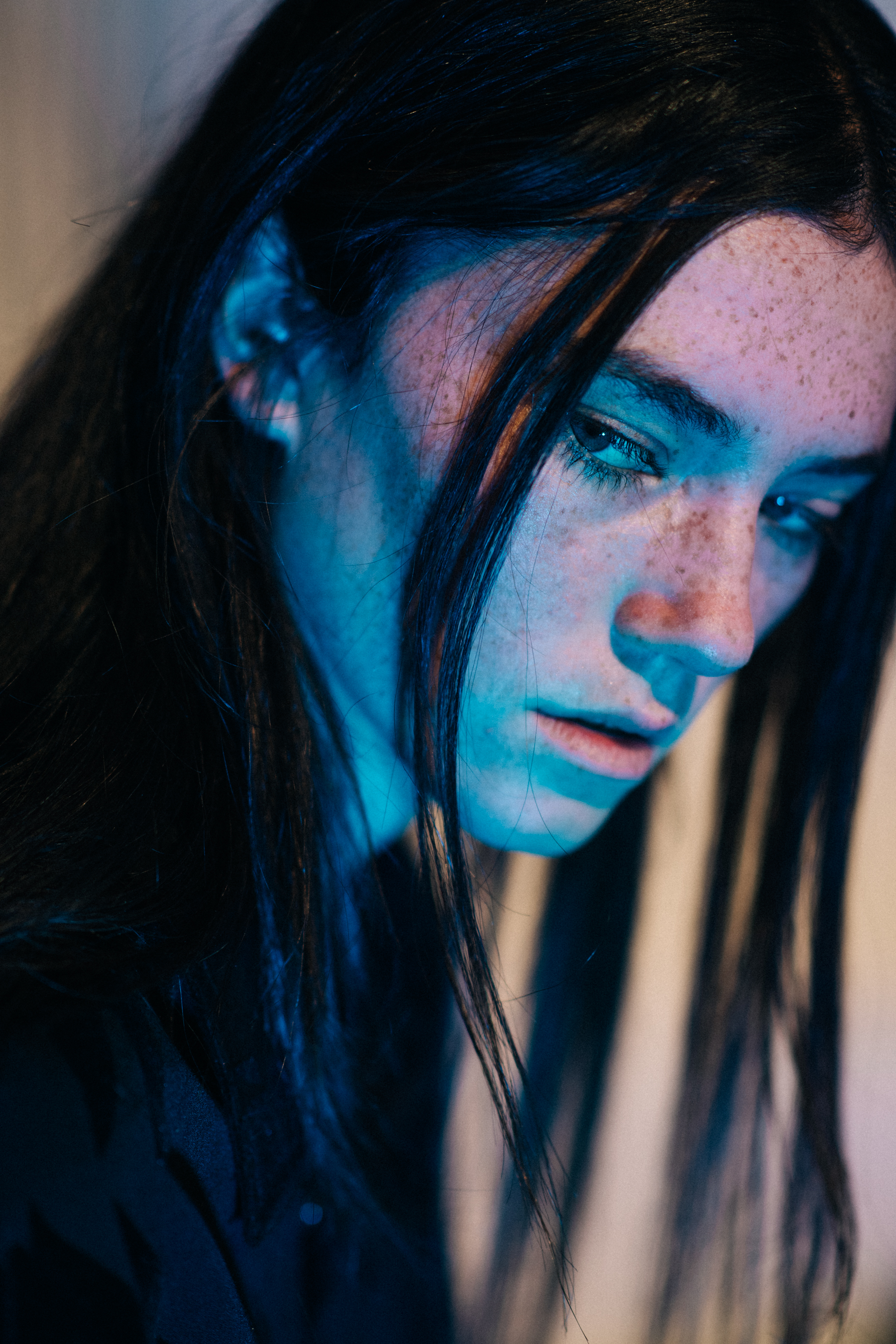 Model with freckles in blue light