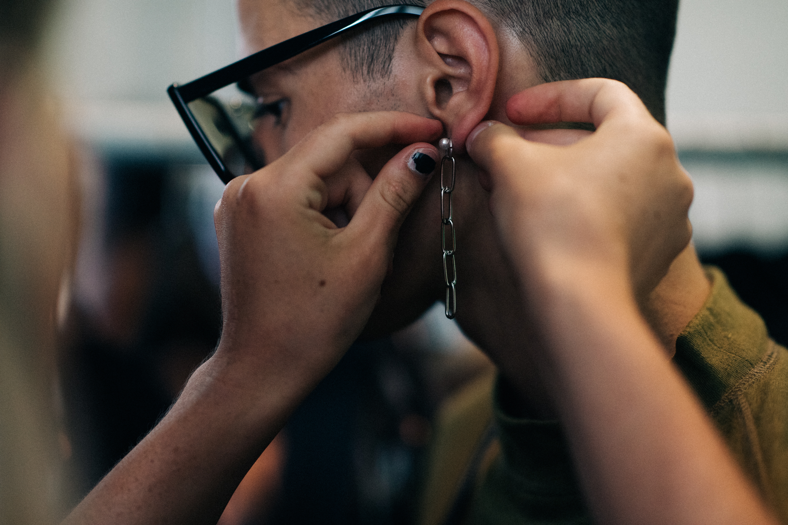 Male model getting earring put on