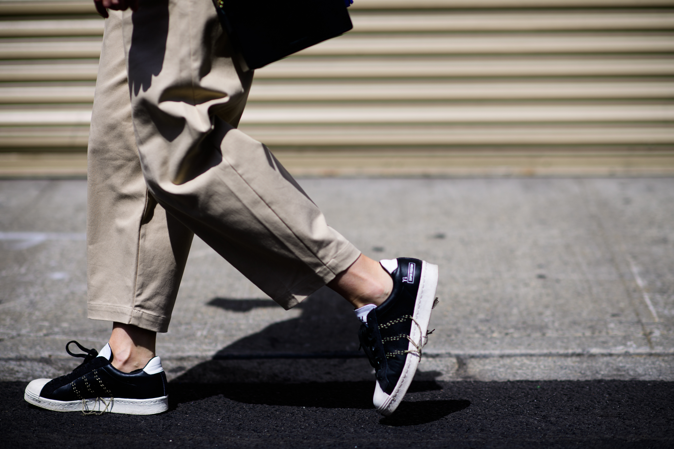 Close up of beige pants and Adidas shoes