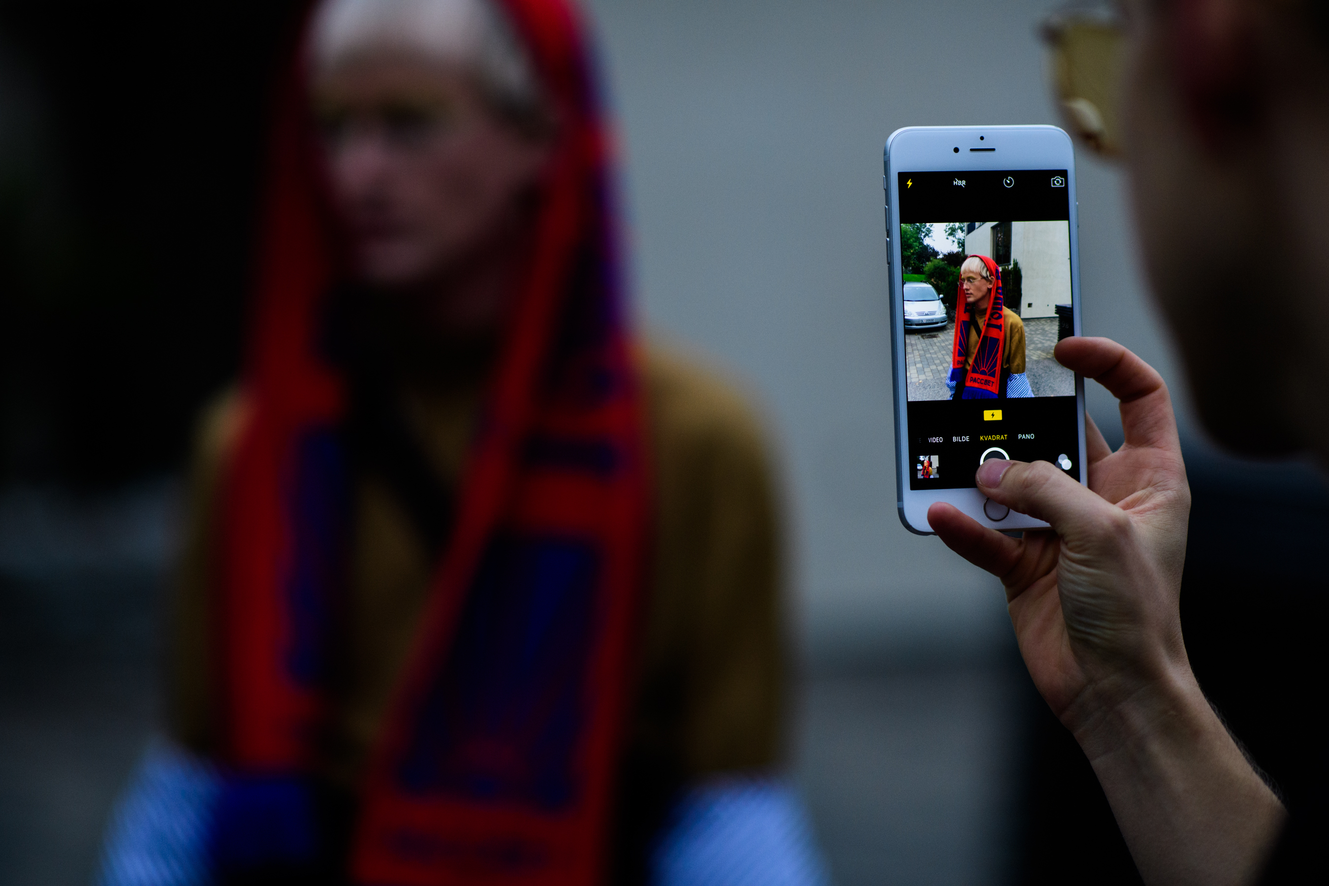 Man taking photo of boy wearing scarf