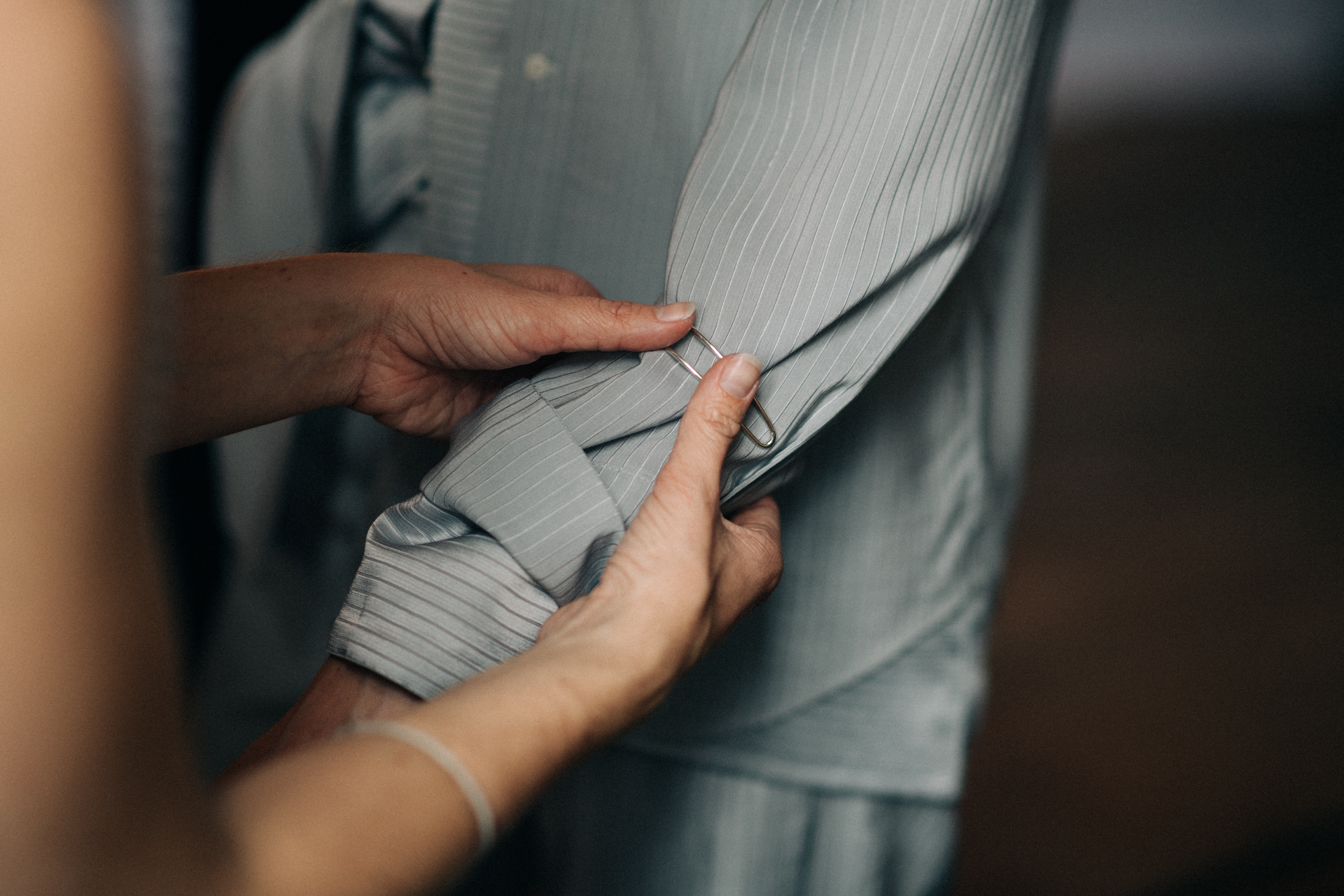 Dresser putting cuffs on the model