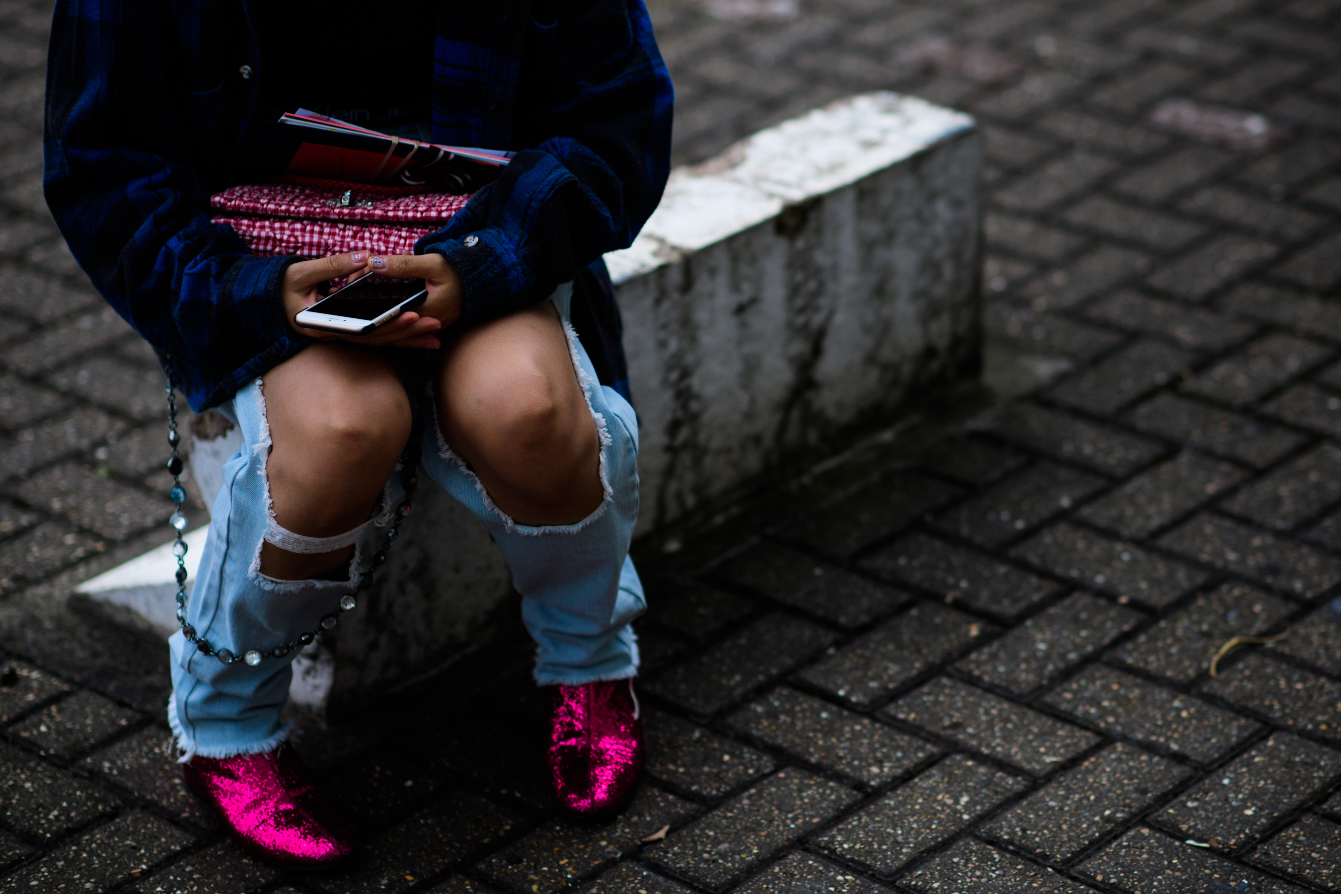 Woman with ripped jeans and pink boots