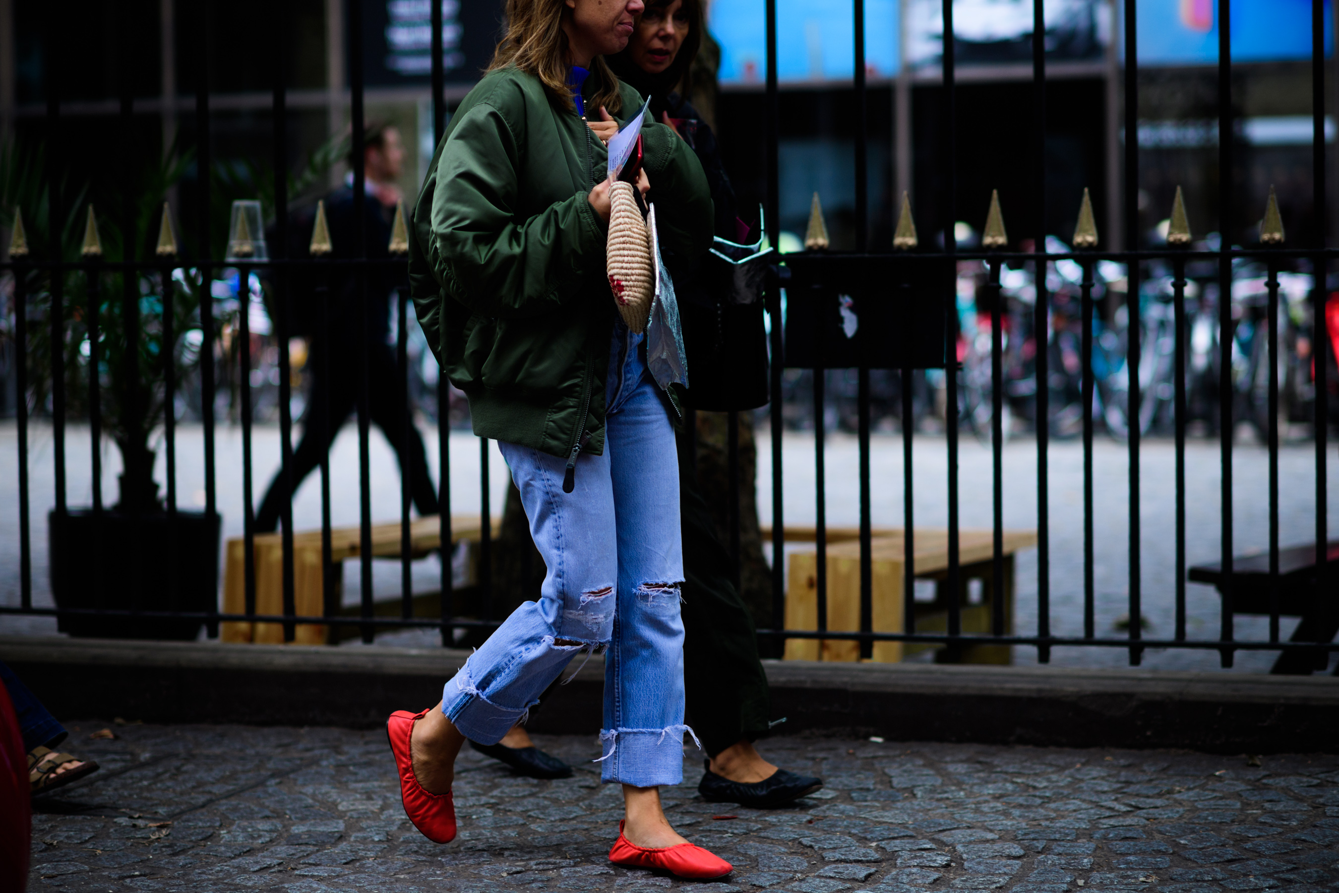 Woman wearing red shoes and bomber