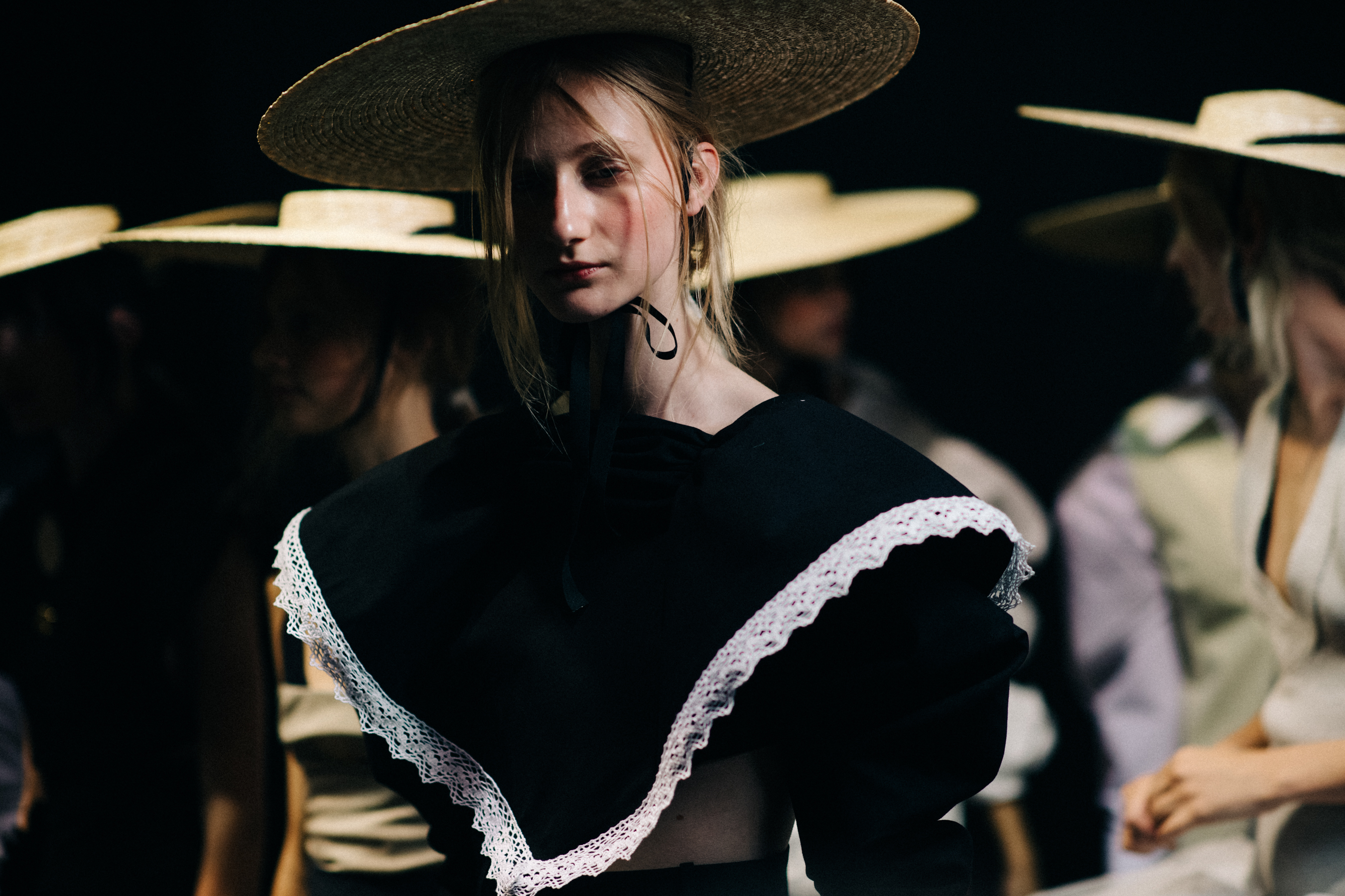 Model wearing oversized straw hat