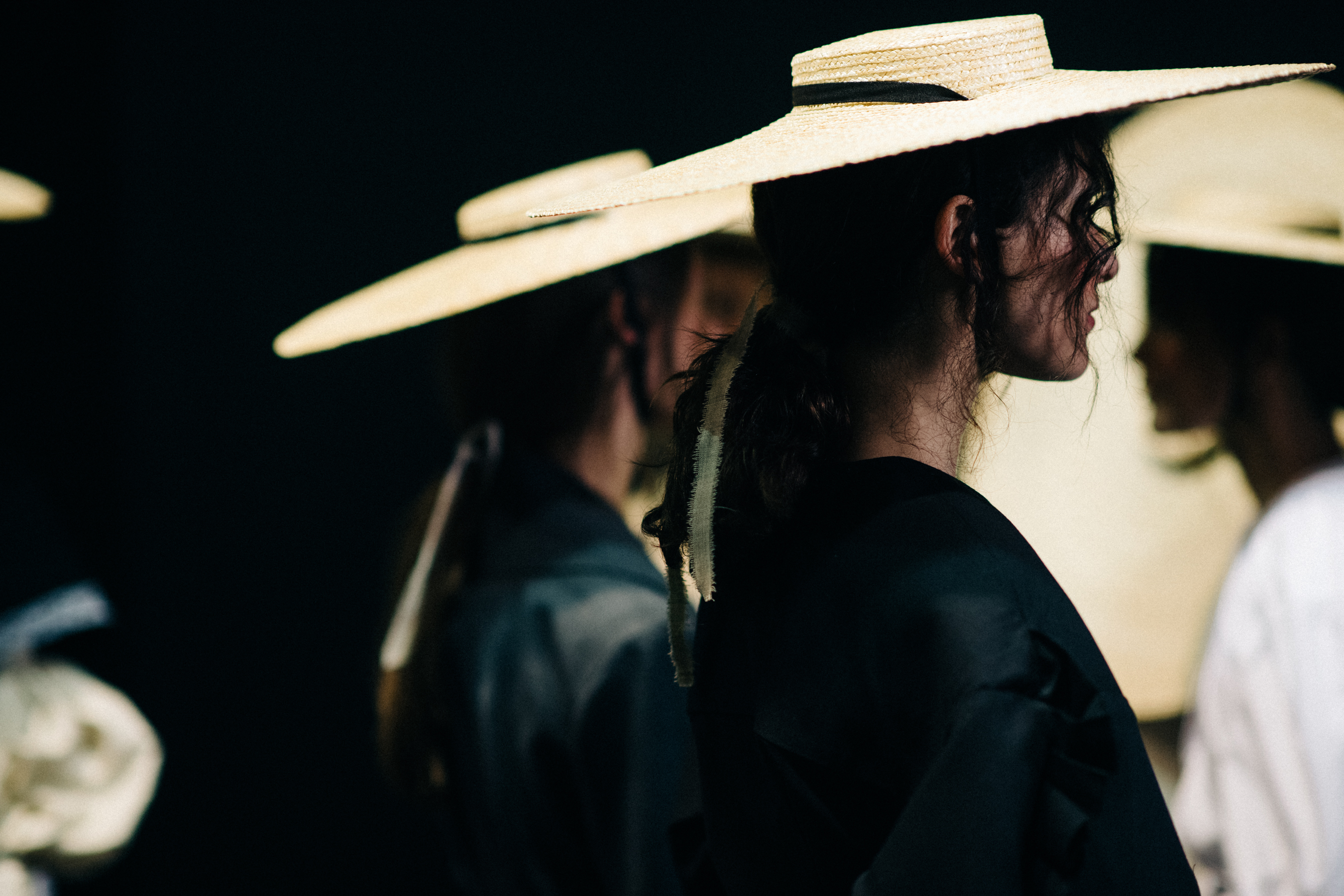 Model wearing oversized straw hat