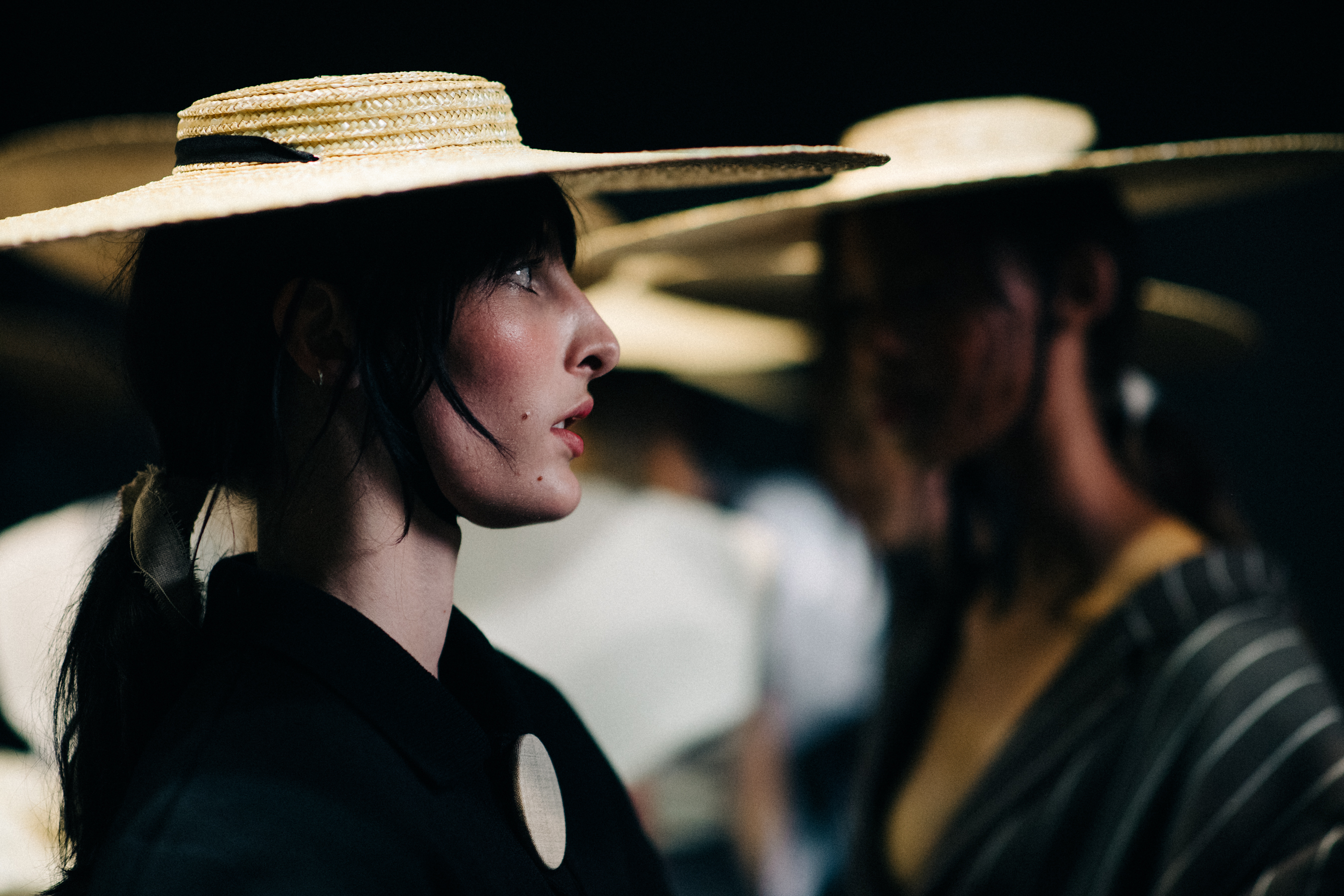 Model wearing oversized straw hat