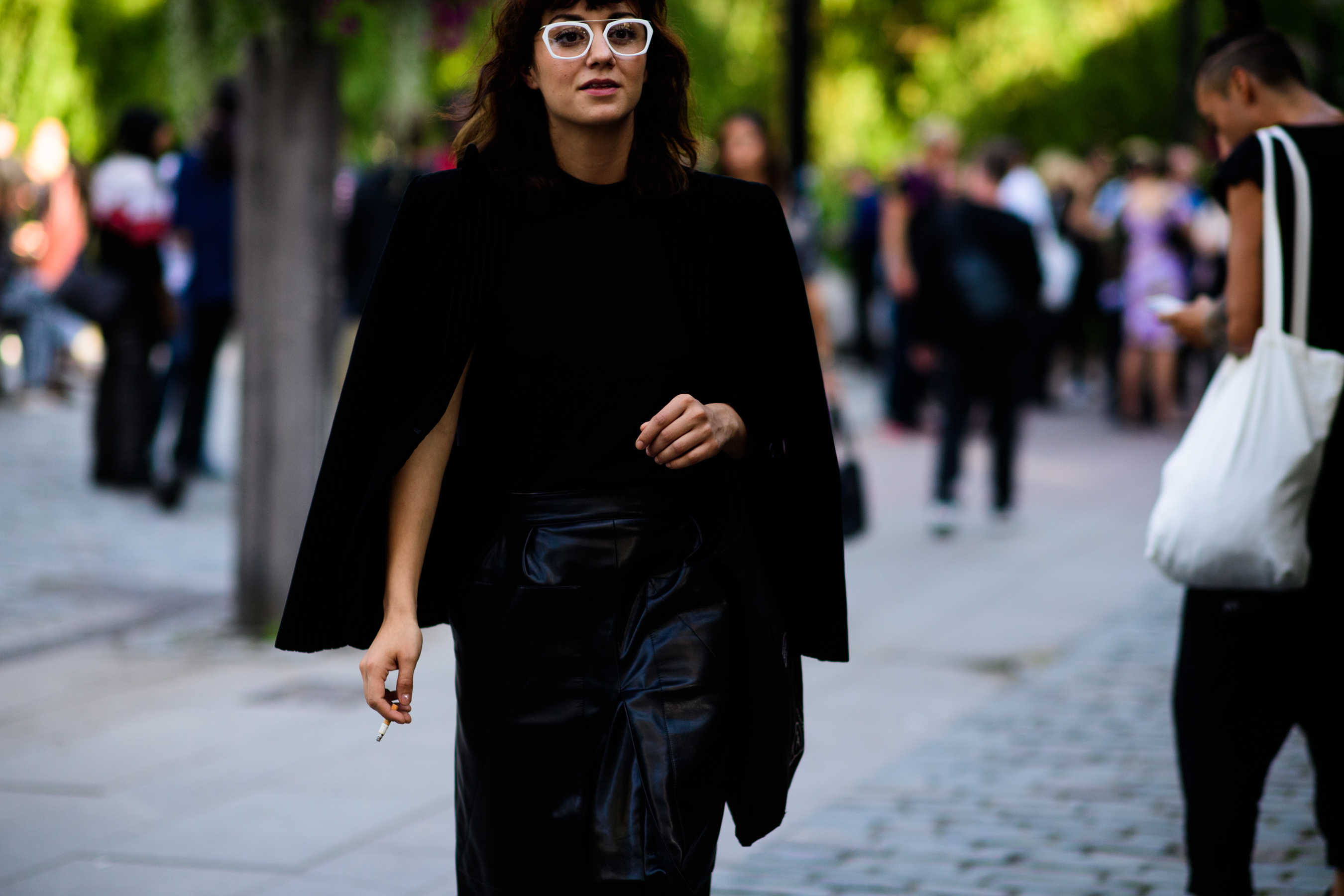 Woman in black wearing white sunglasses