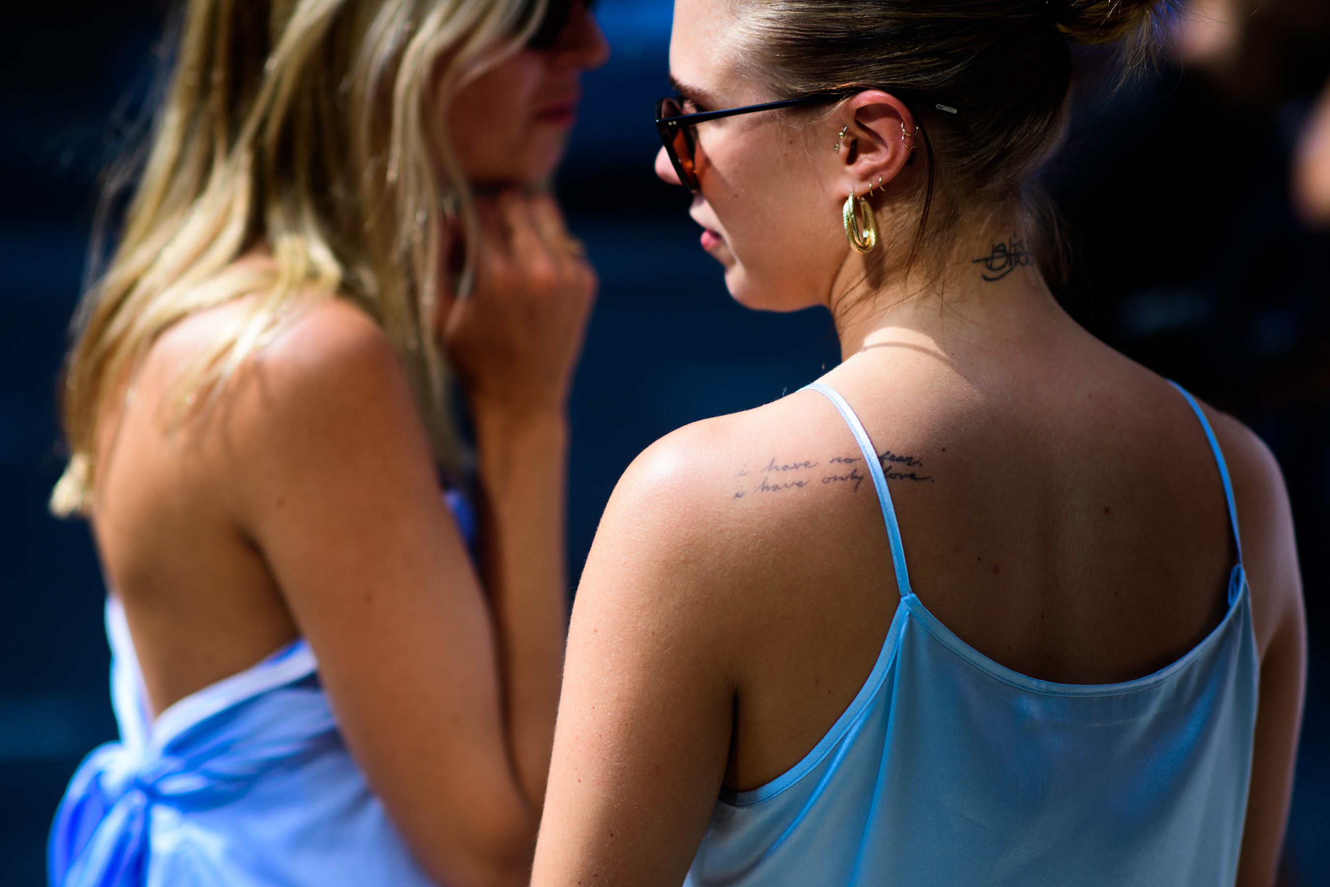 Two women wearing blue tops