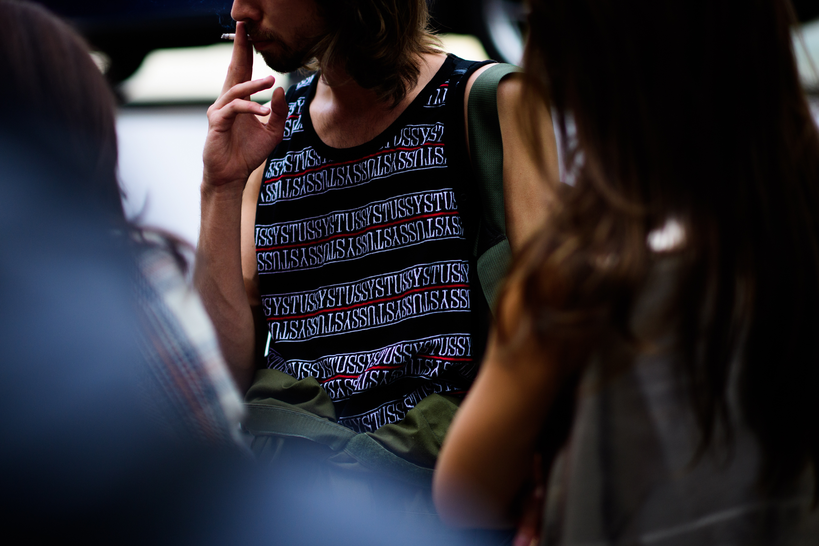 Man wearing Stussy shirt smoking