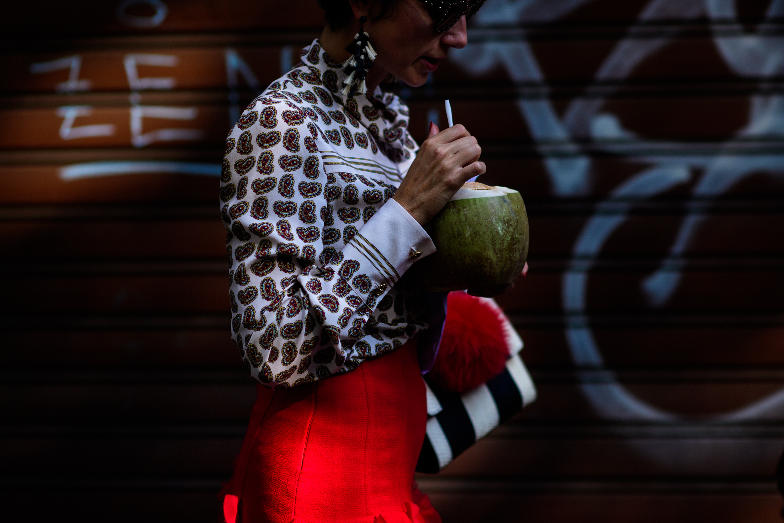 Woman drinking coconut after Dolce & Gabbana