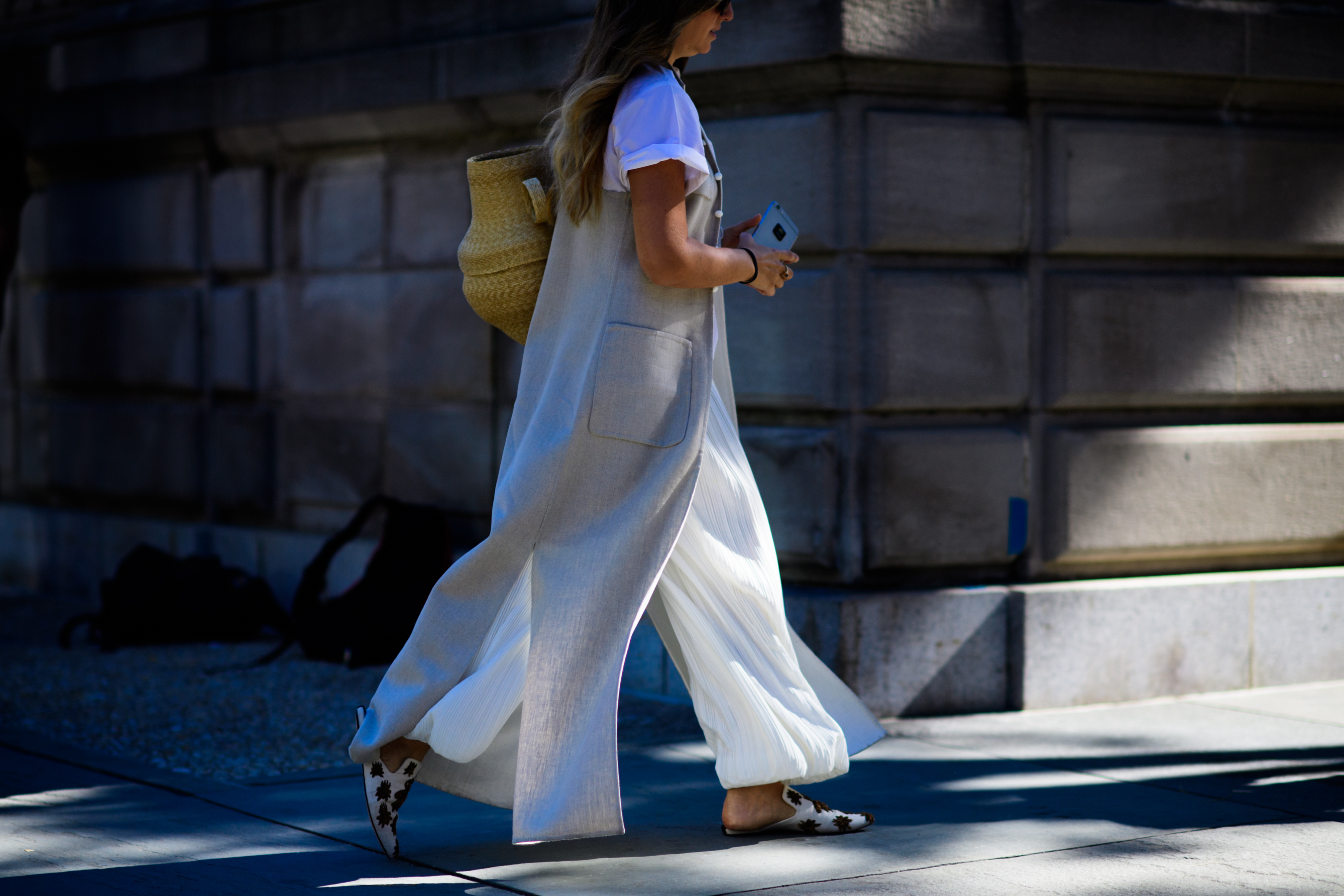 Woman wearing grey vest and white