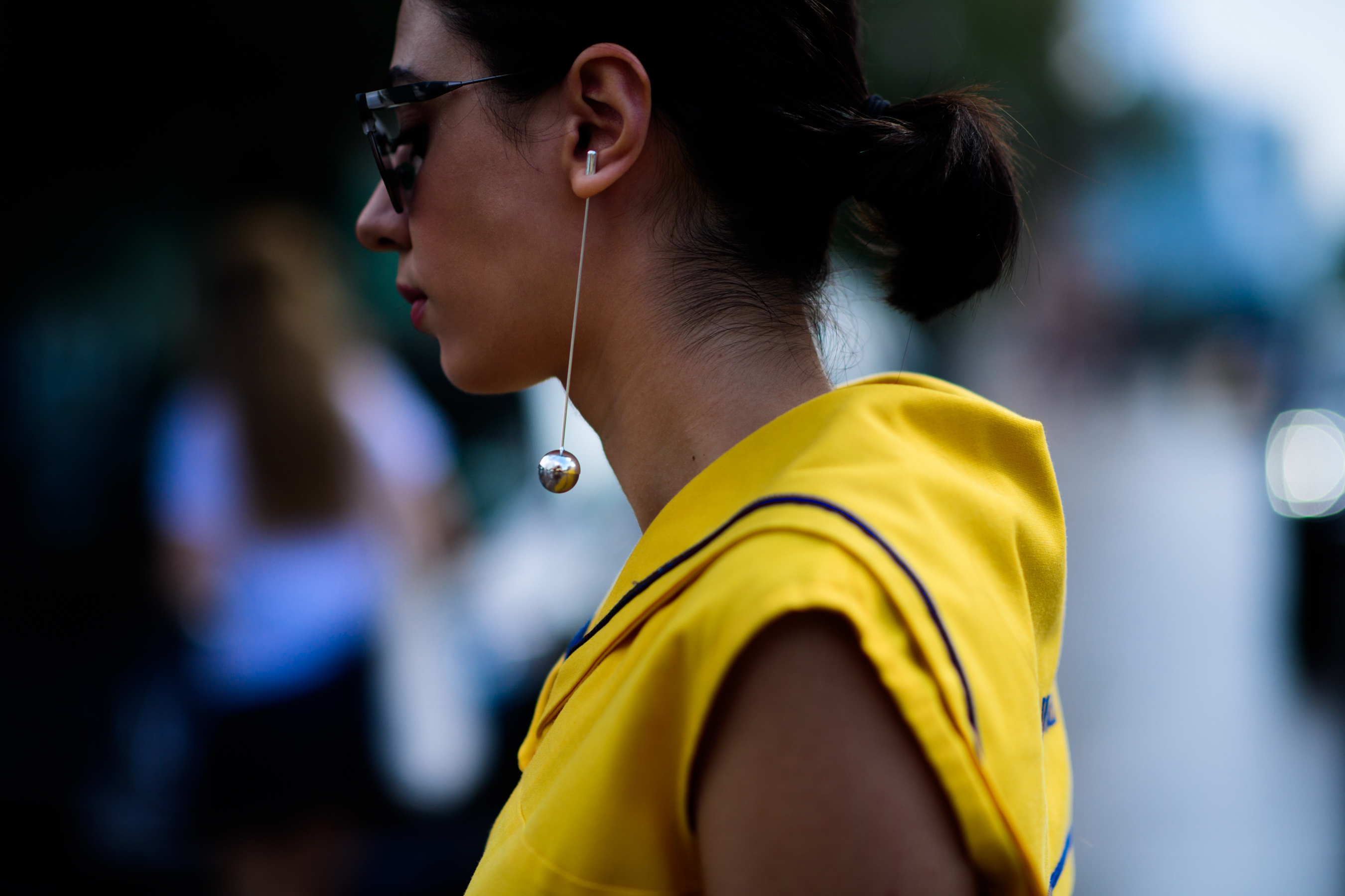 Woman wearing long earring with ball