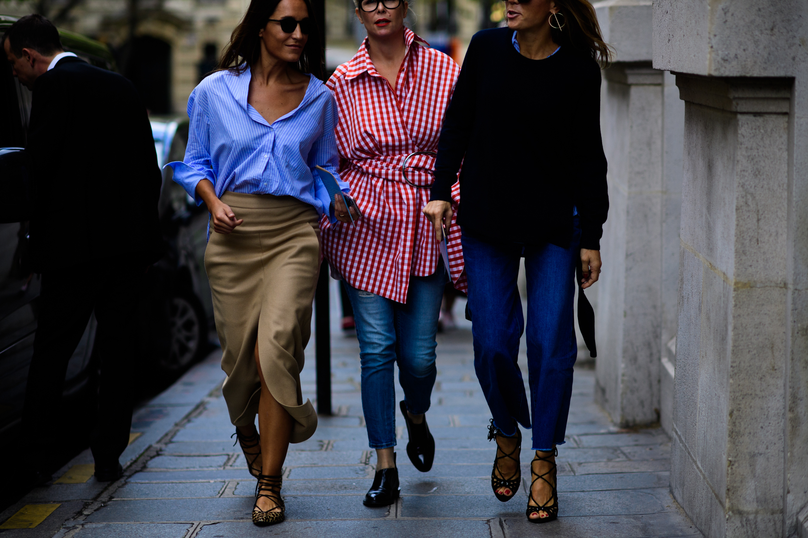 Three women wearing shirts walking