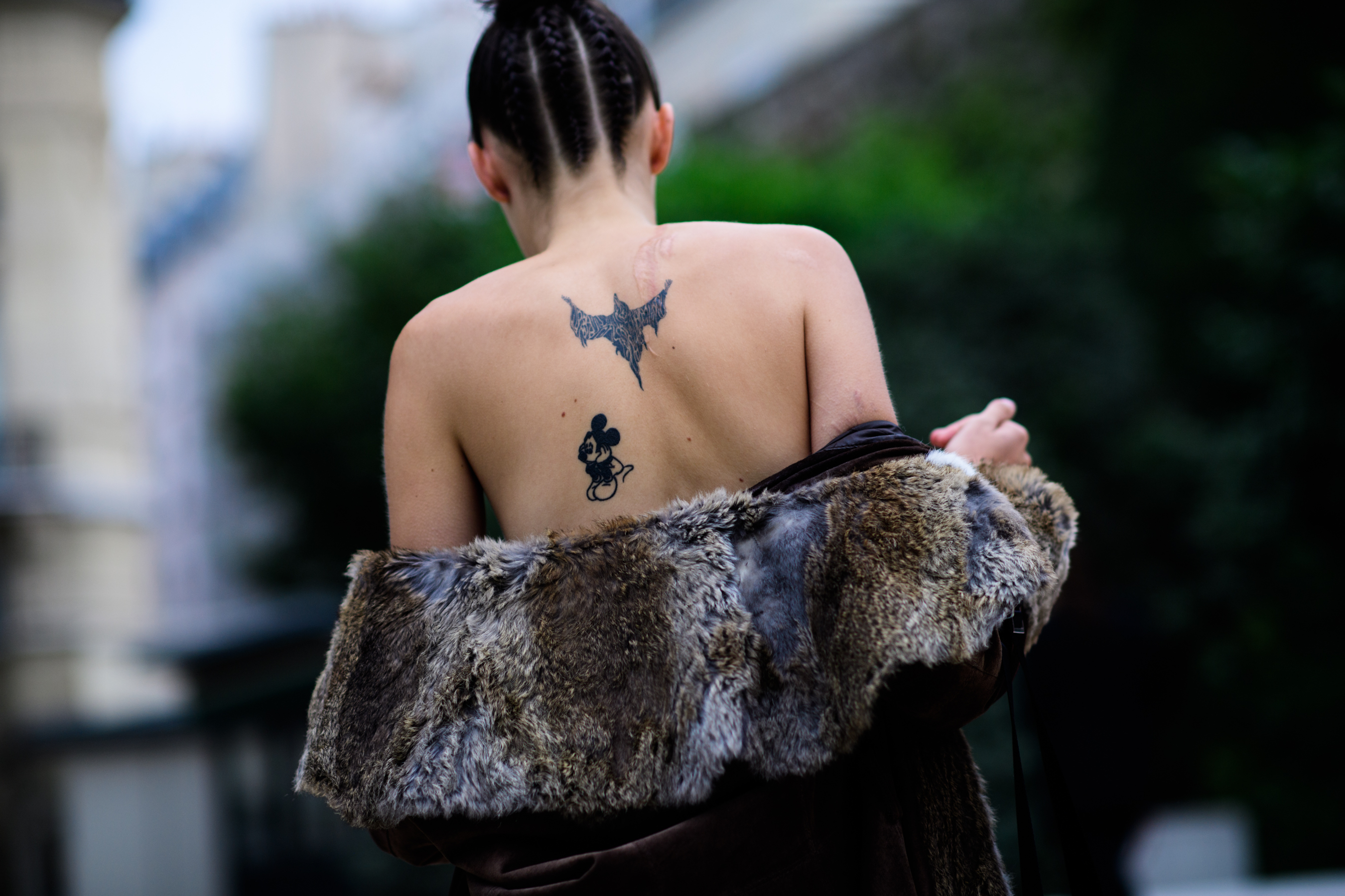 Back of model showing two tattoos and fur coat