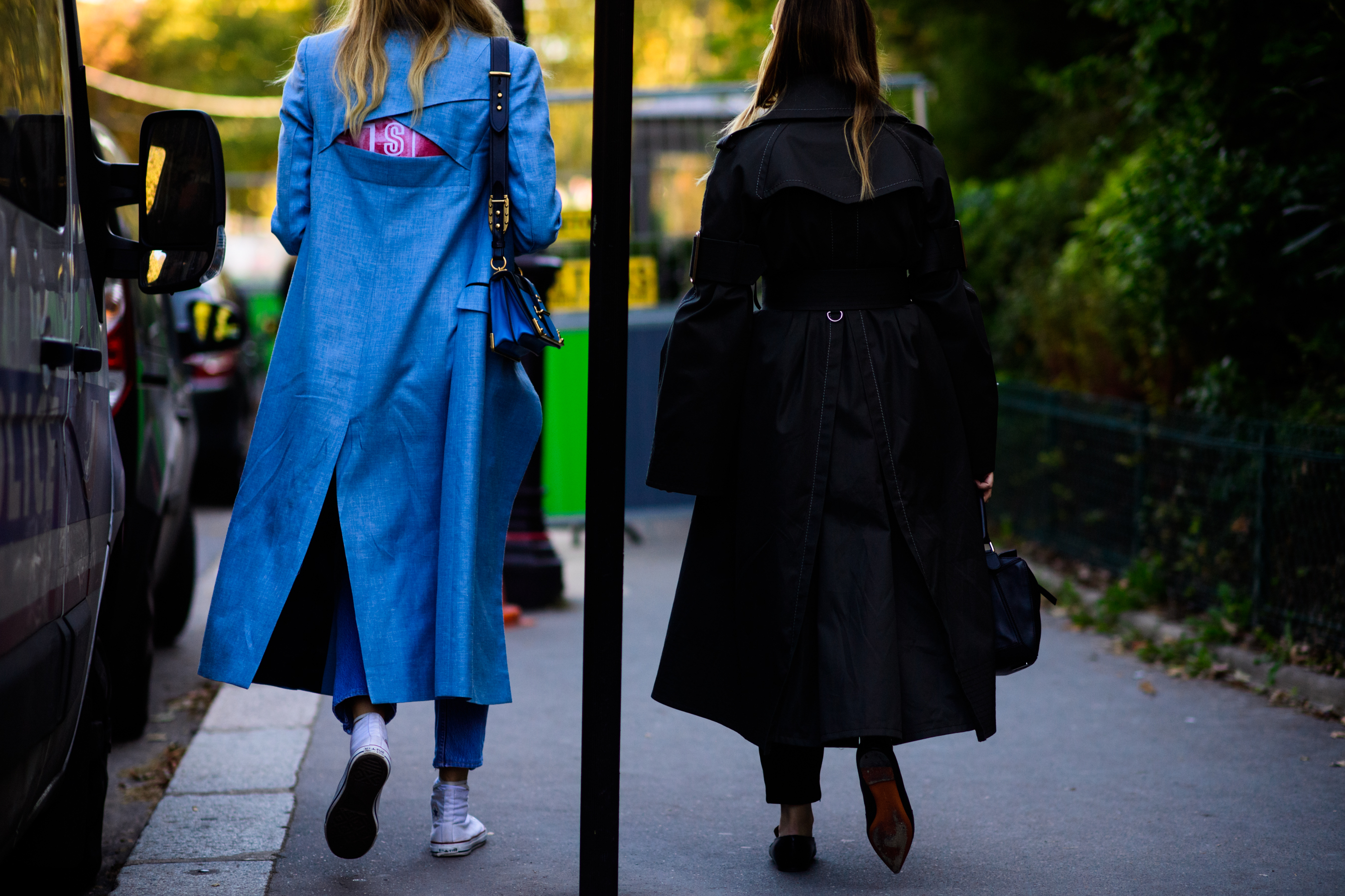 Two women in long trench coats
