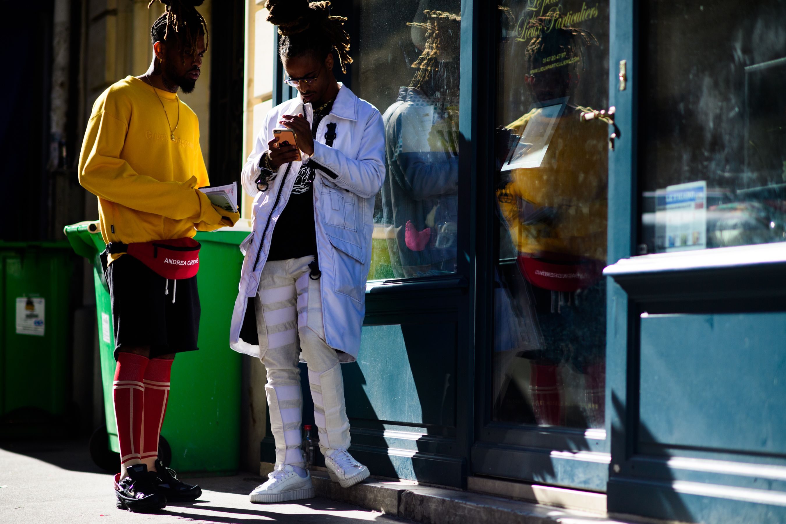 Two men with braided hair in harsh sunlight