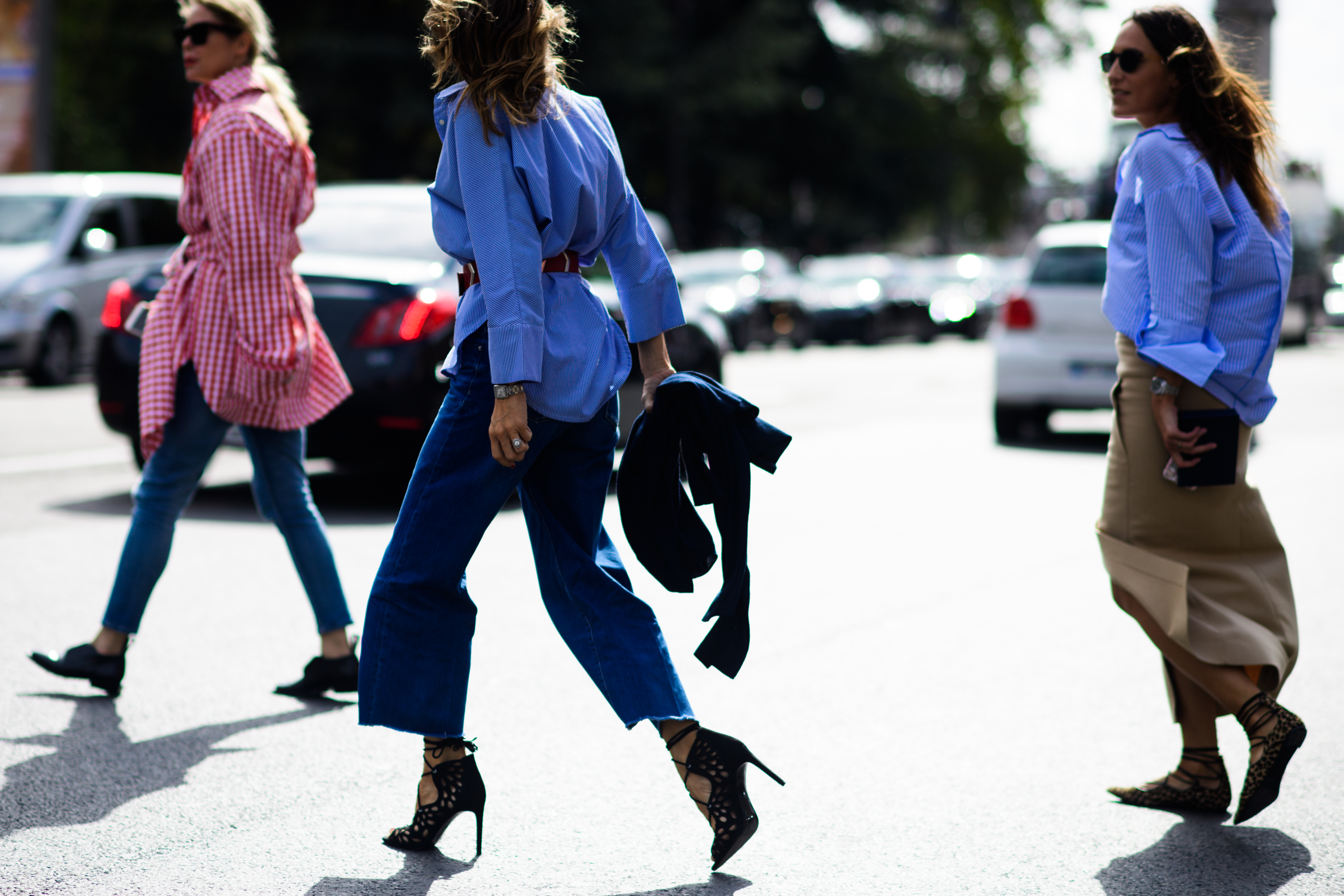 Three women crossing the road in oversized shirts