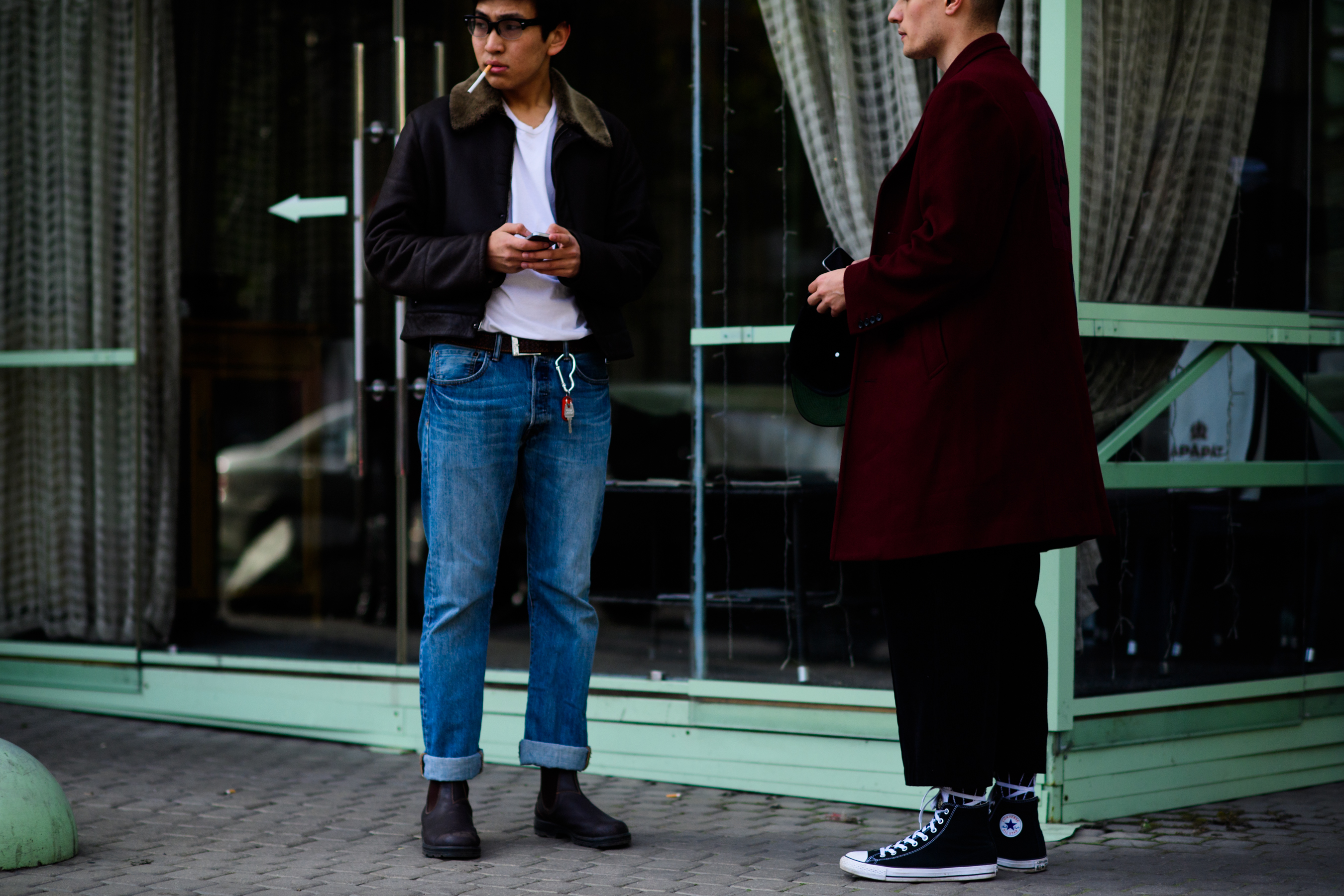 Two guys wearing jeans and coats