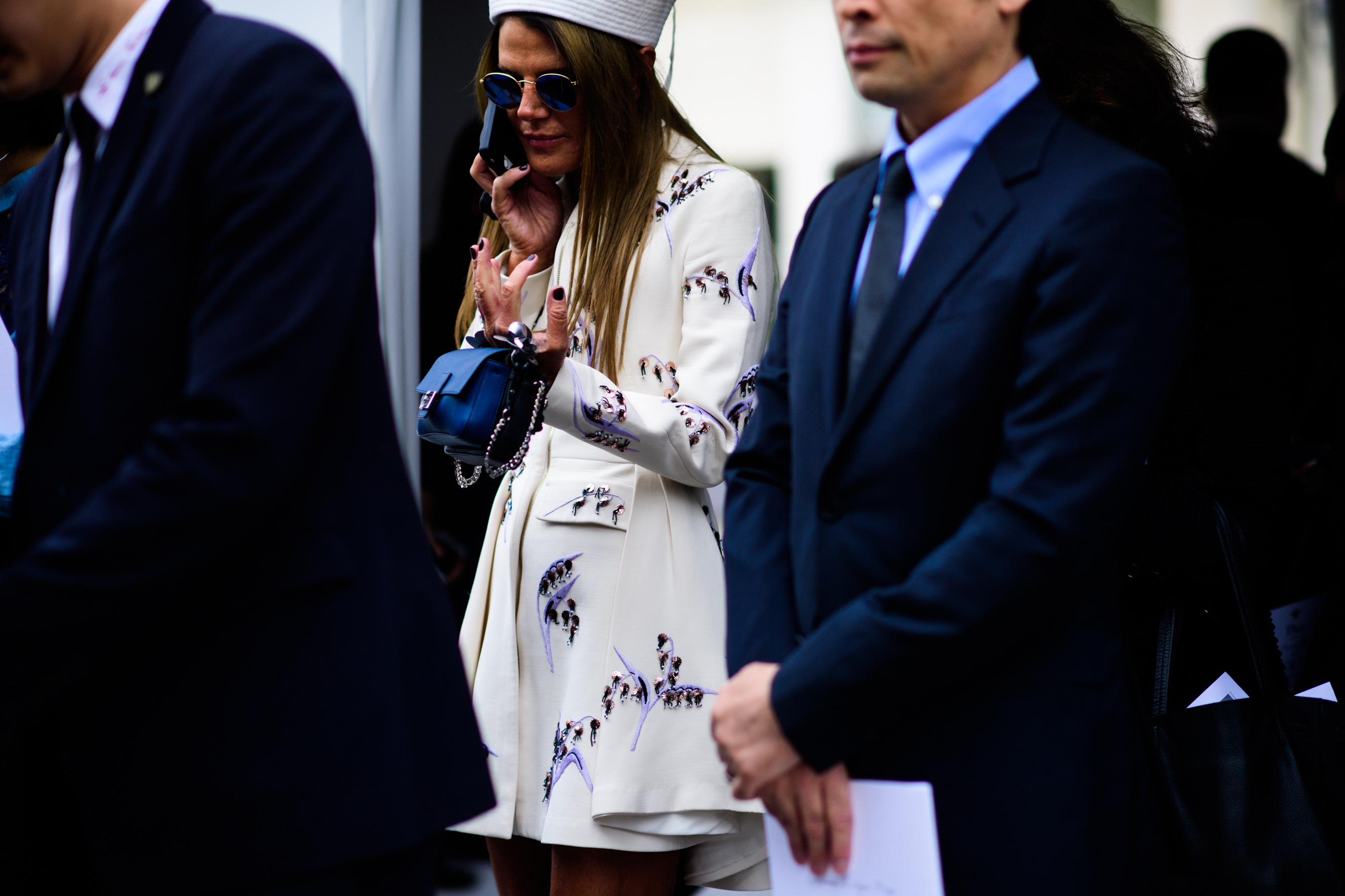 Editor on phone in white floral pattern dress