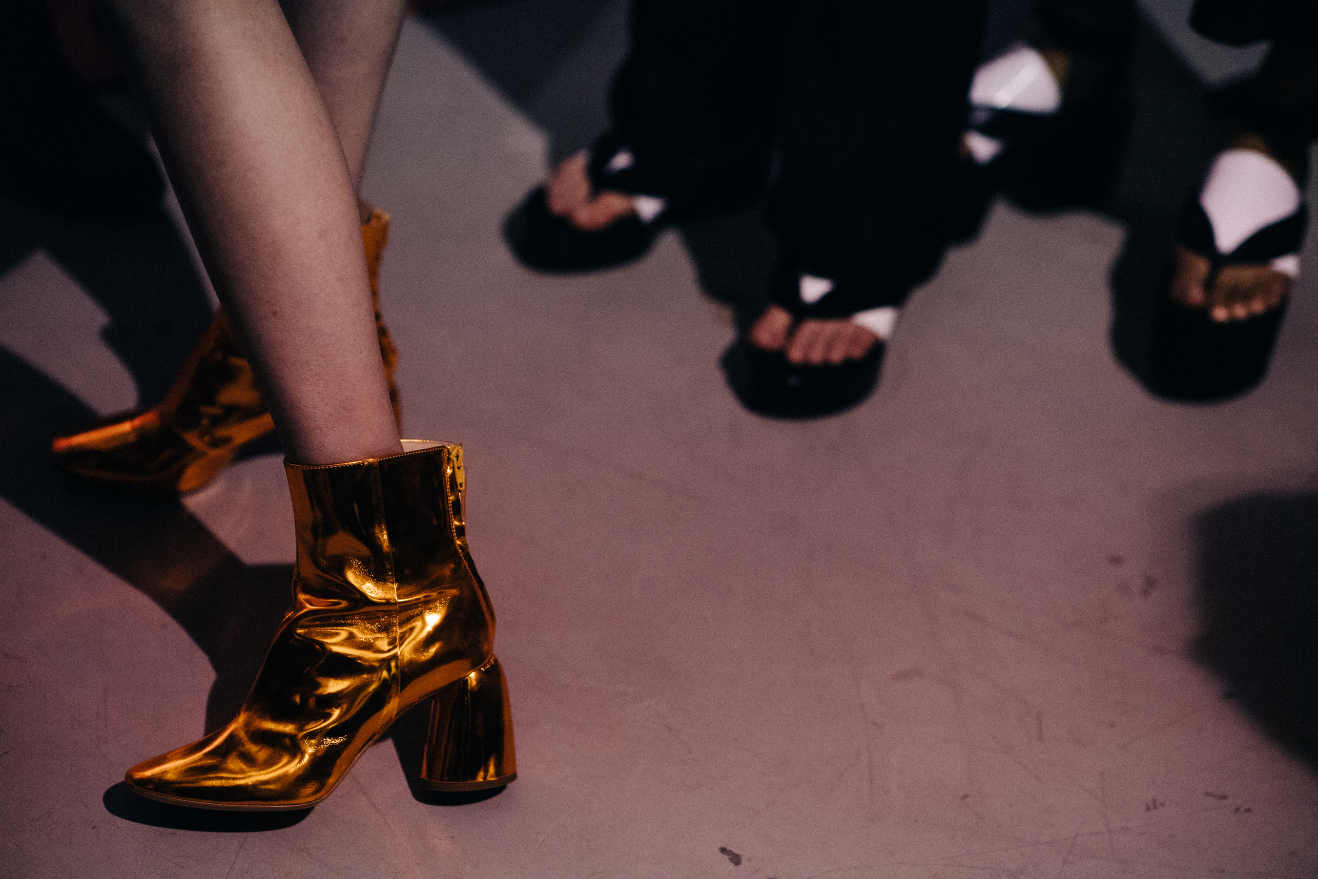Models wearing shiny golden boots