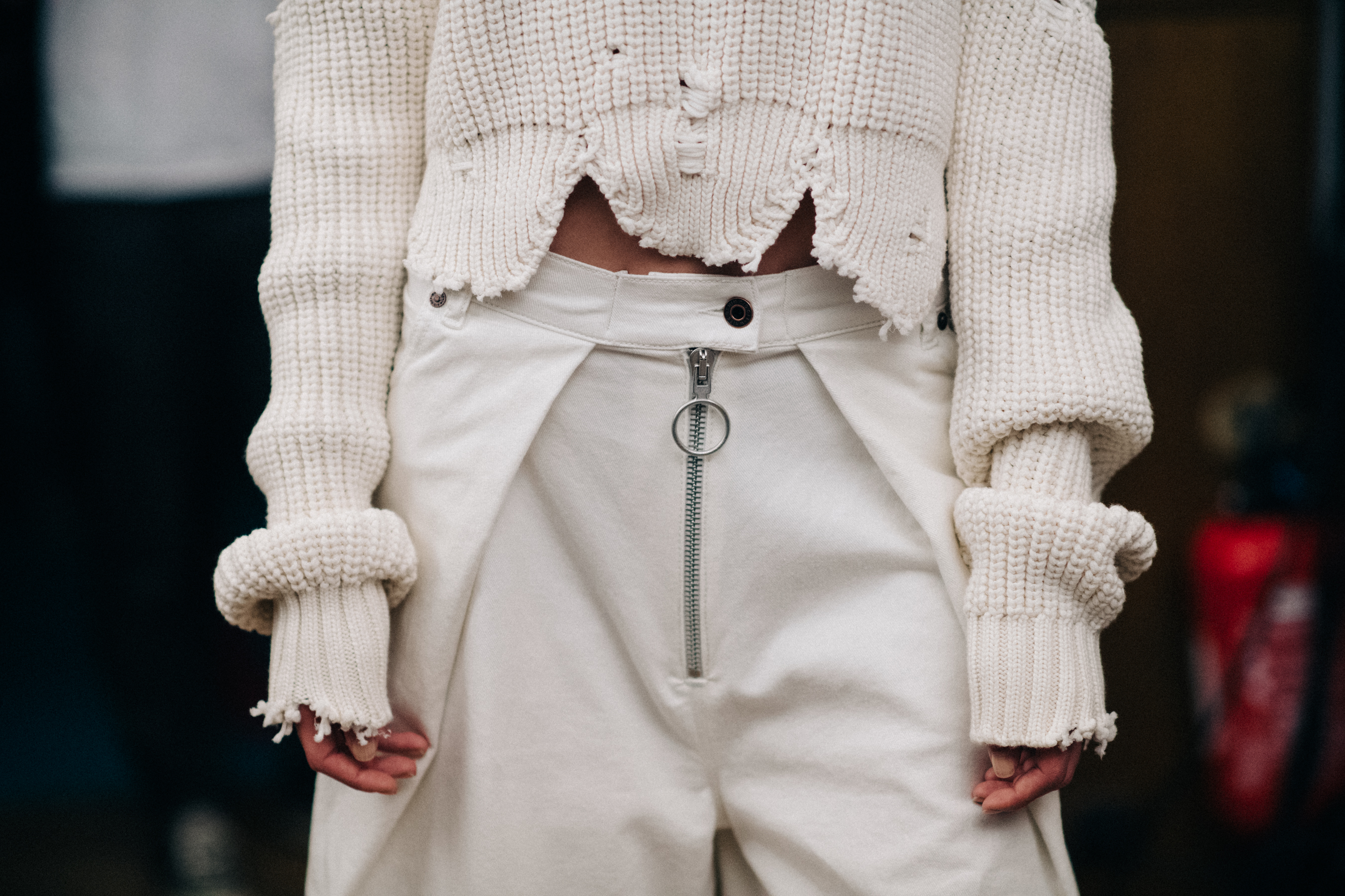 Model wearing white sweater and trousers