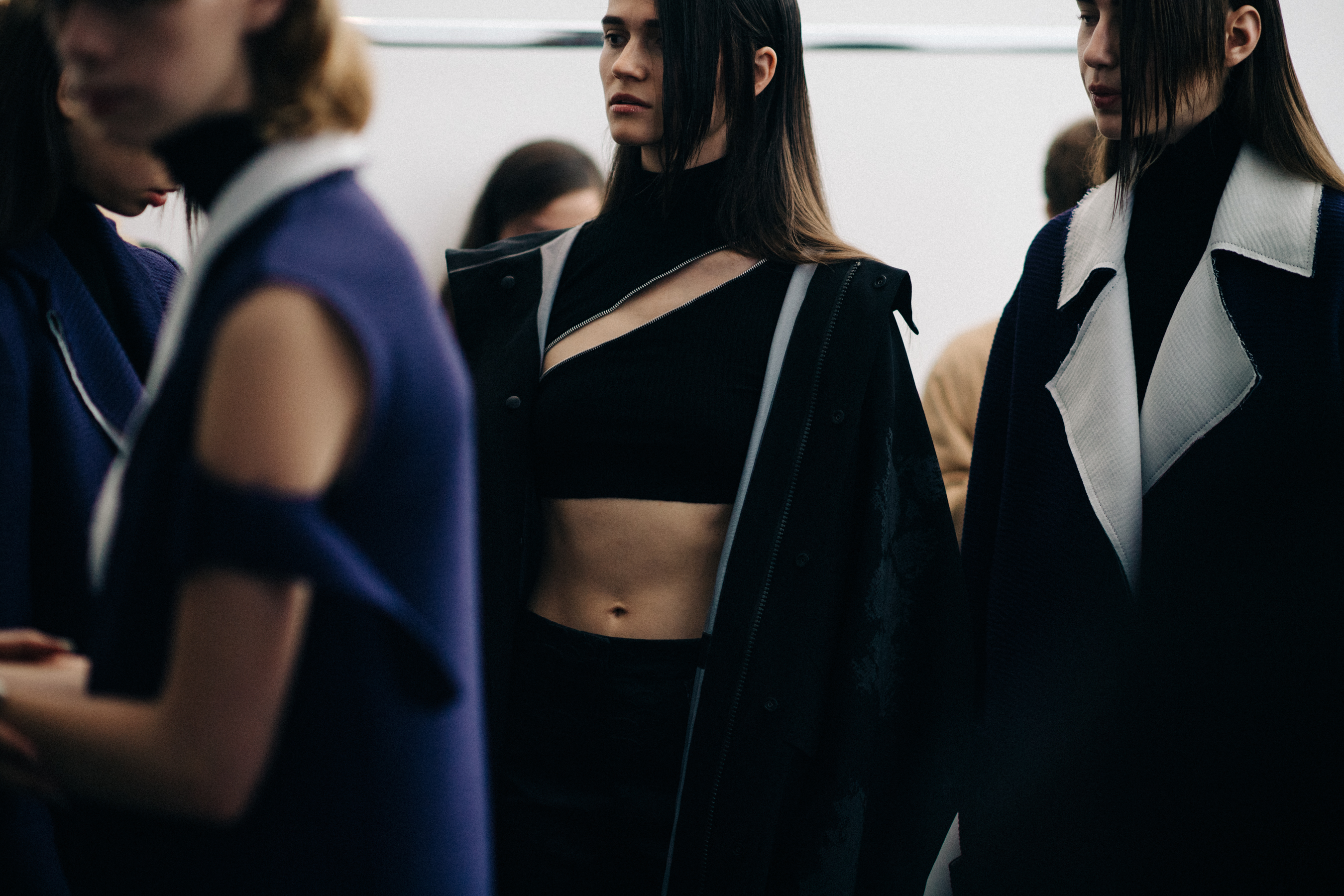 Models wearing dark clothing before the show