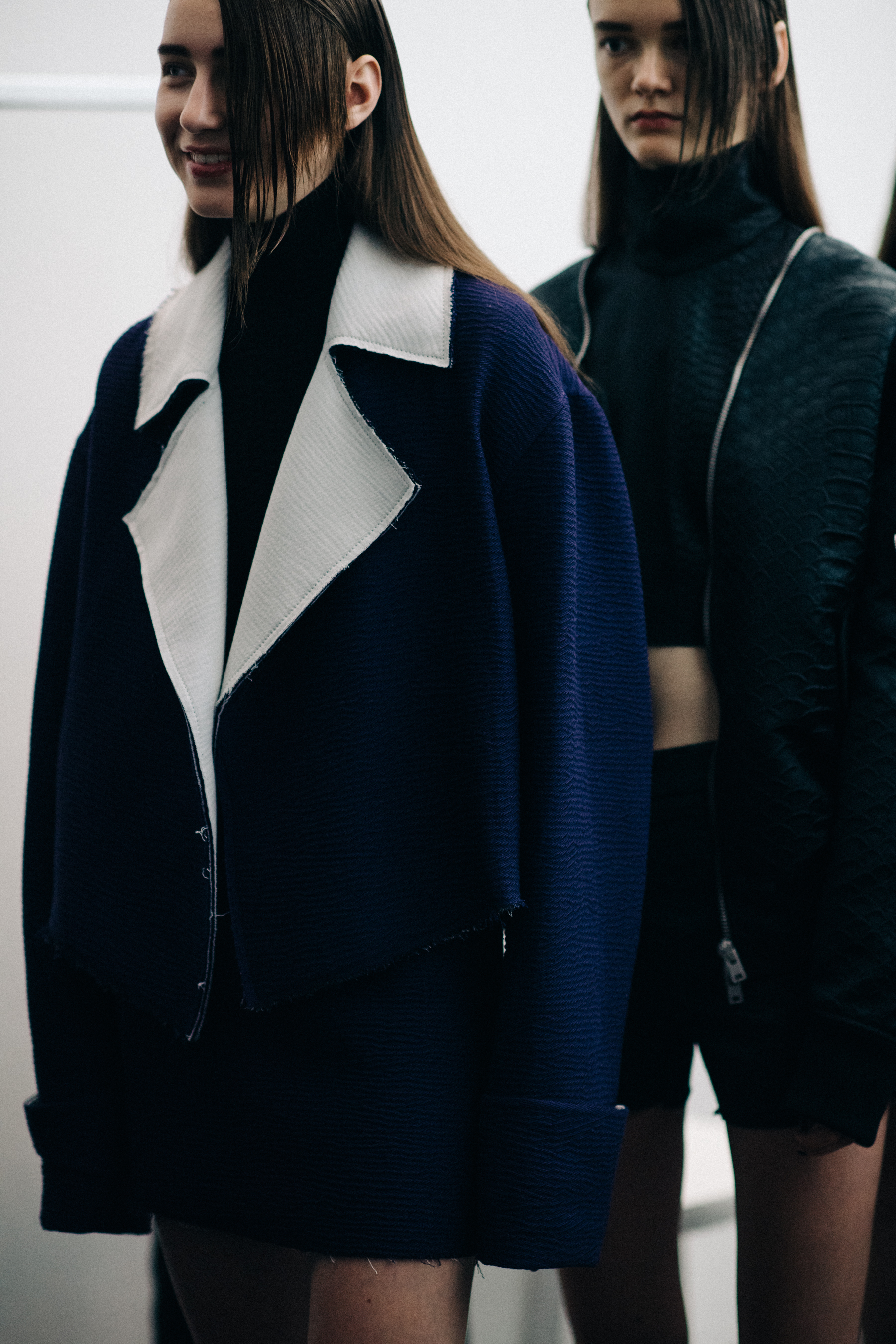 Models wearing dark clothing before the show