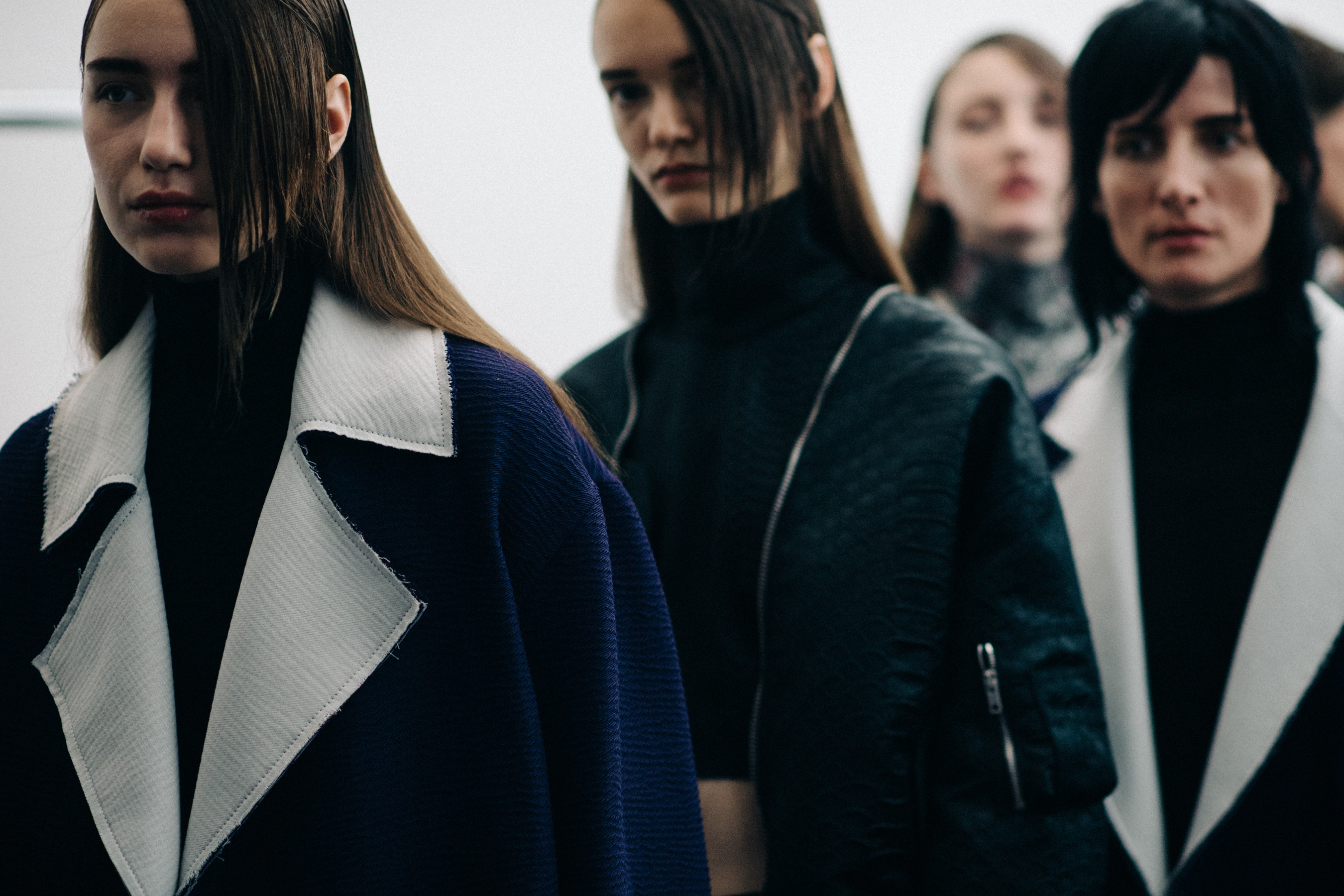 Models wearing dark clothing before the show