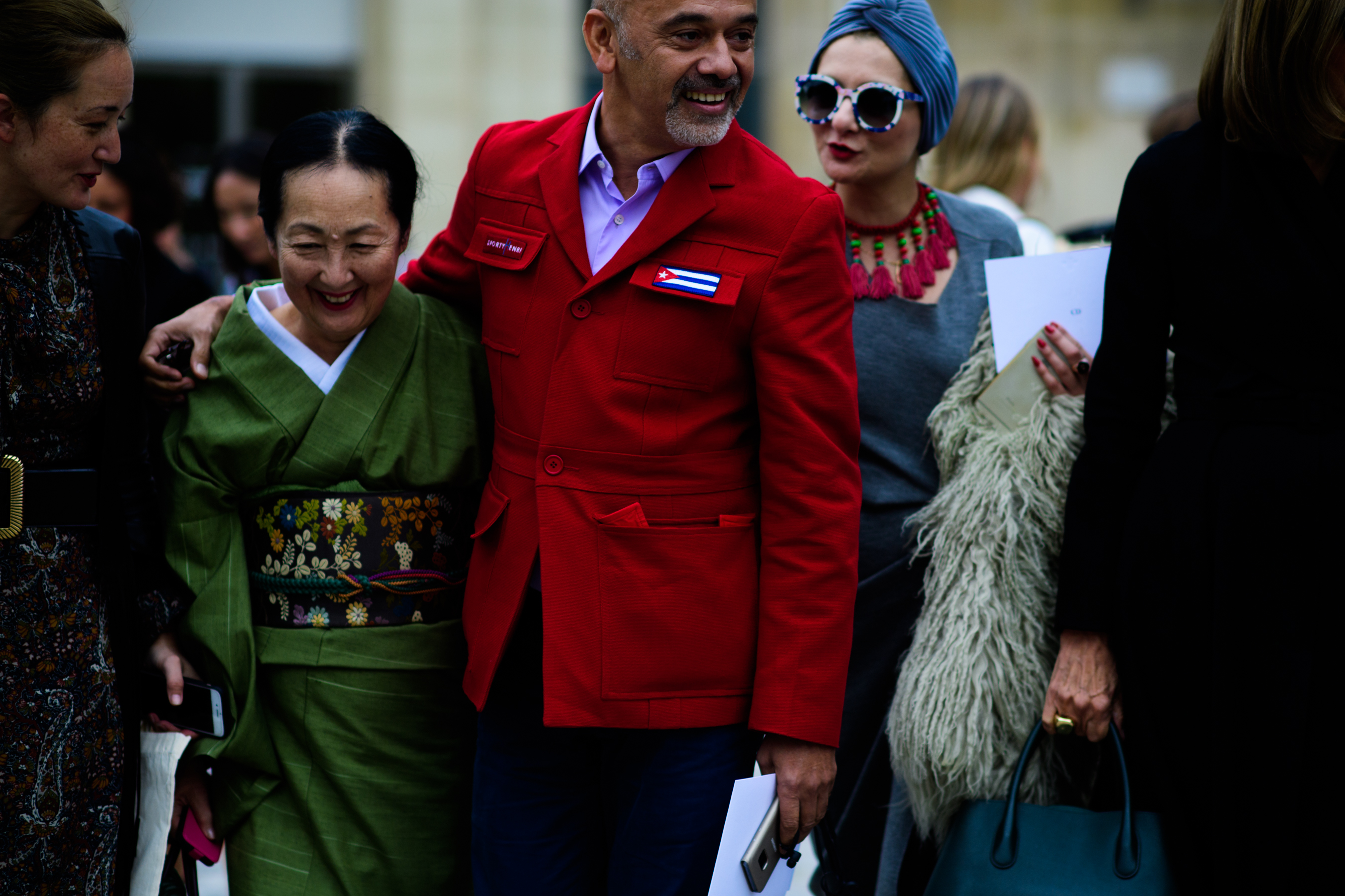 Designer in red with arm around woman in green
