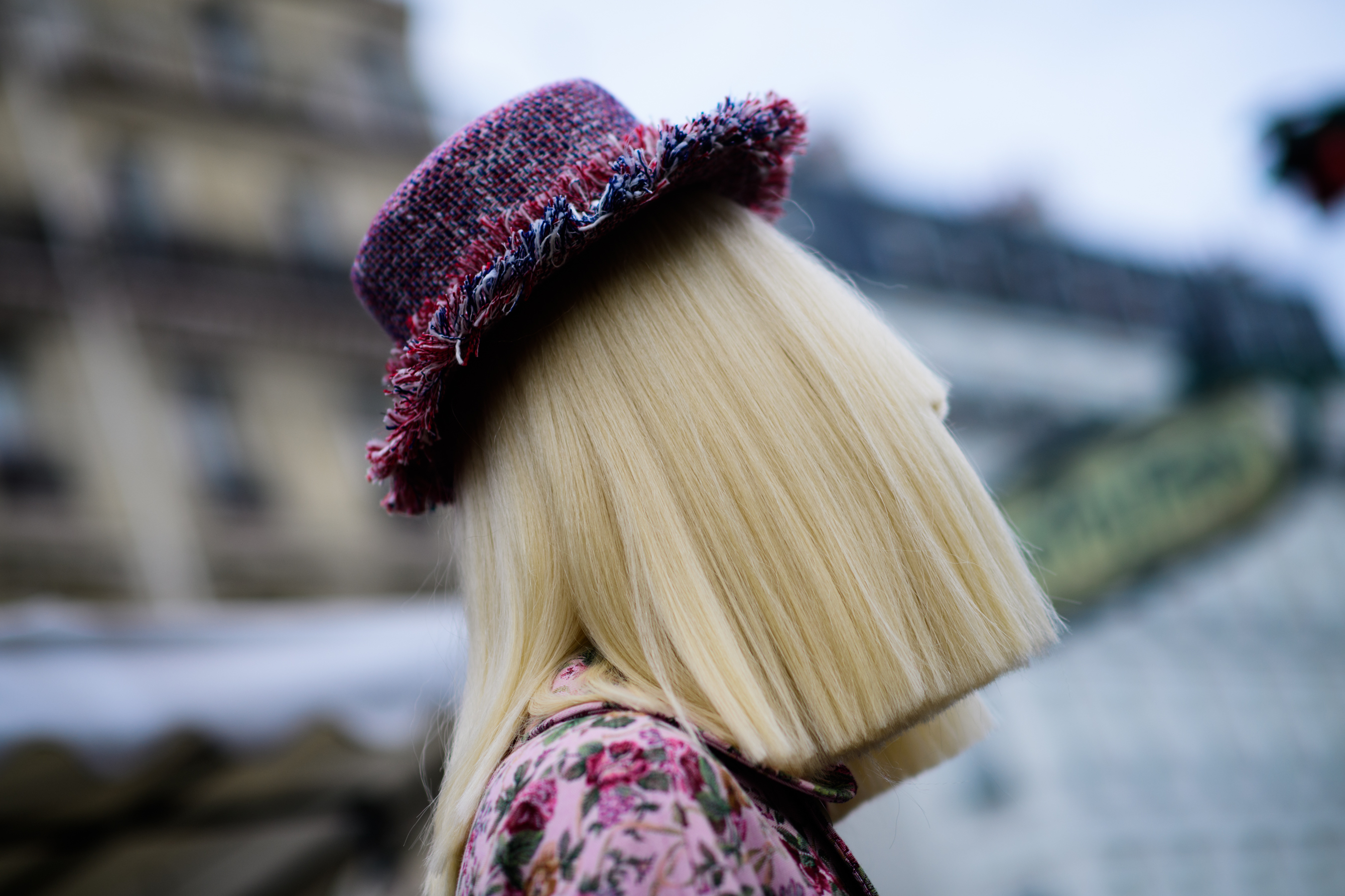 Closeup of woman with cropped blonde hair and pink hat