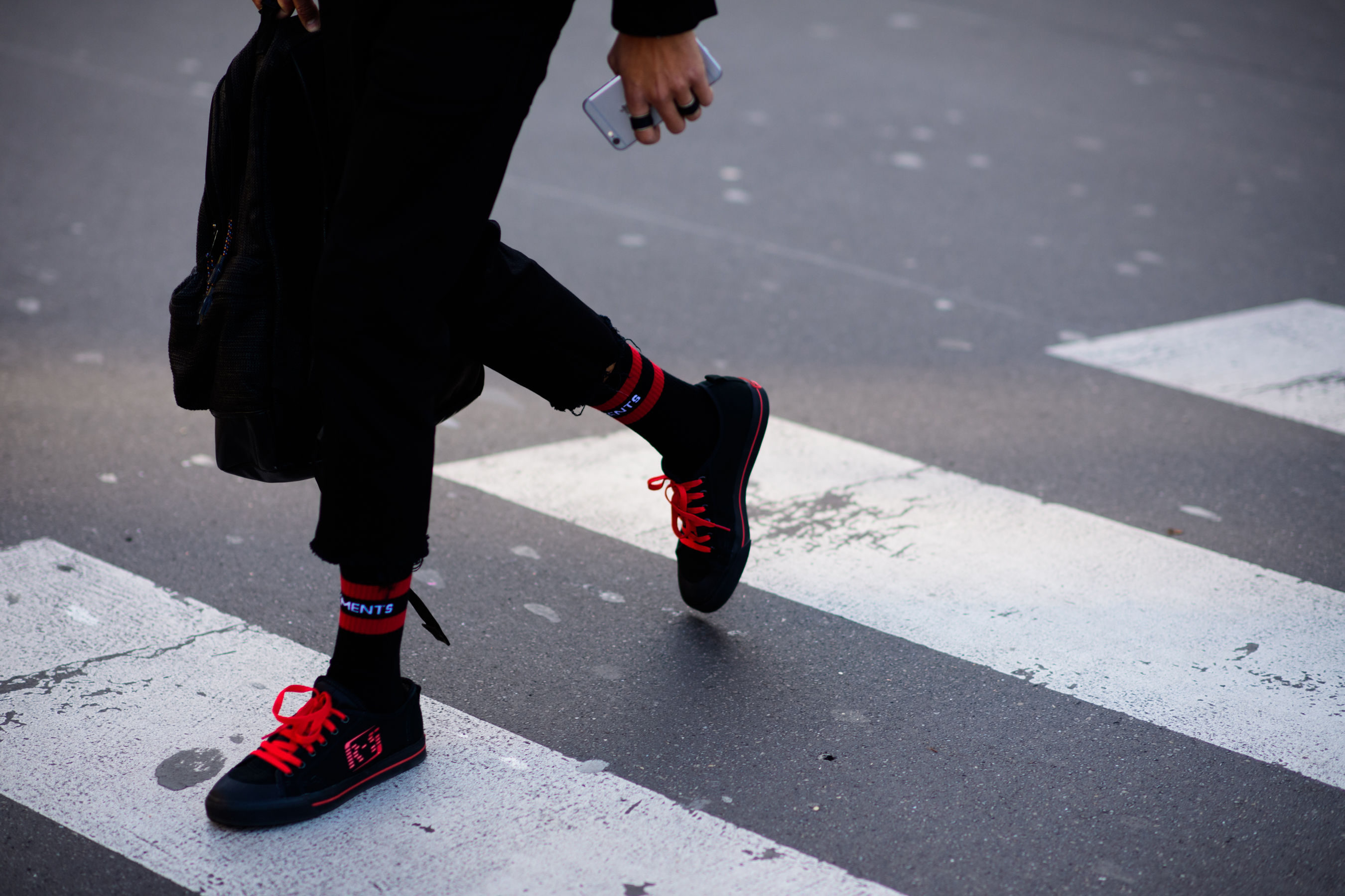 Closeup of mans feet wearing red and black sneakers