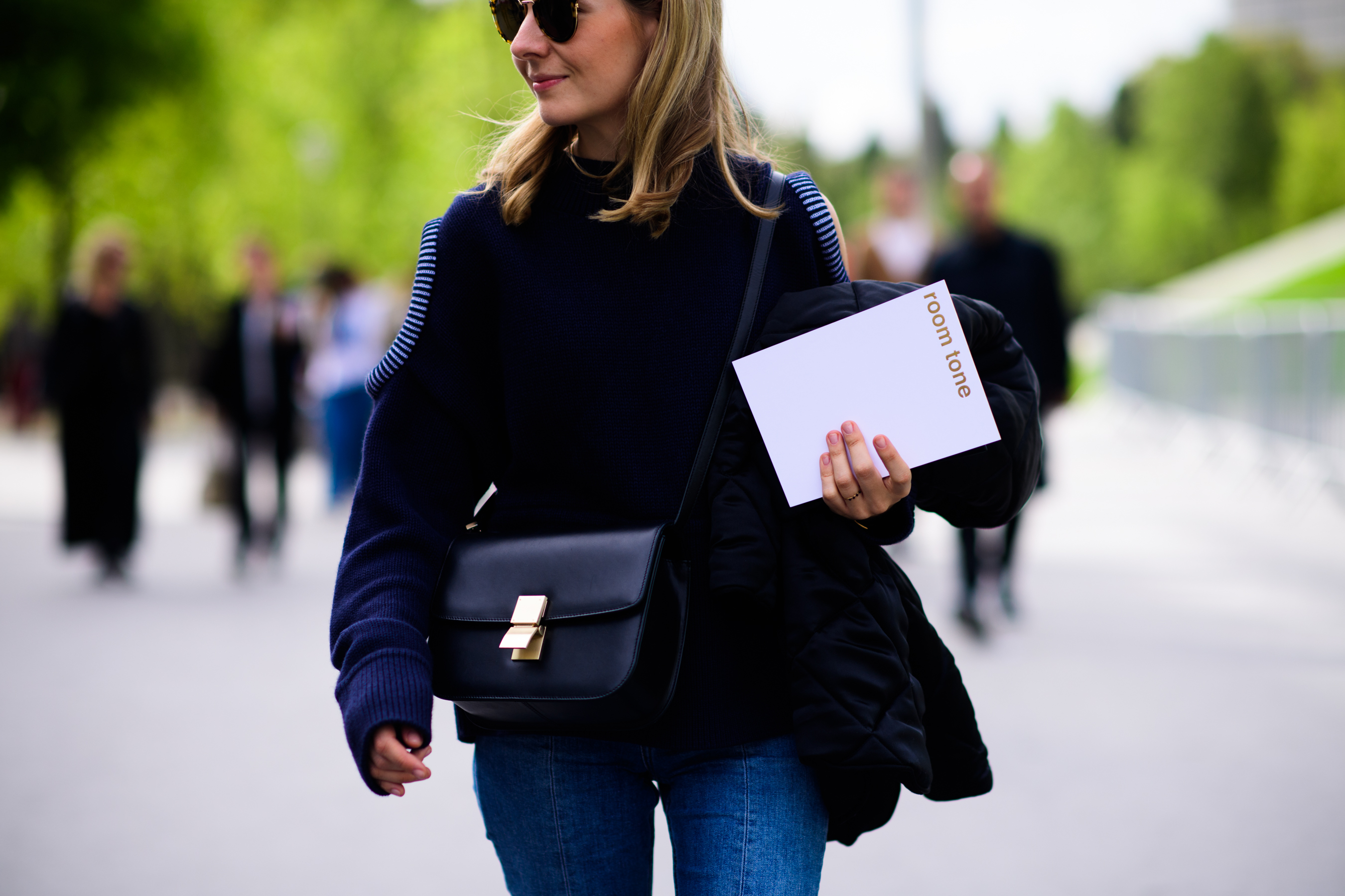 Woman wearing blue knit jumper holding white paper