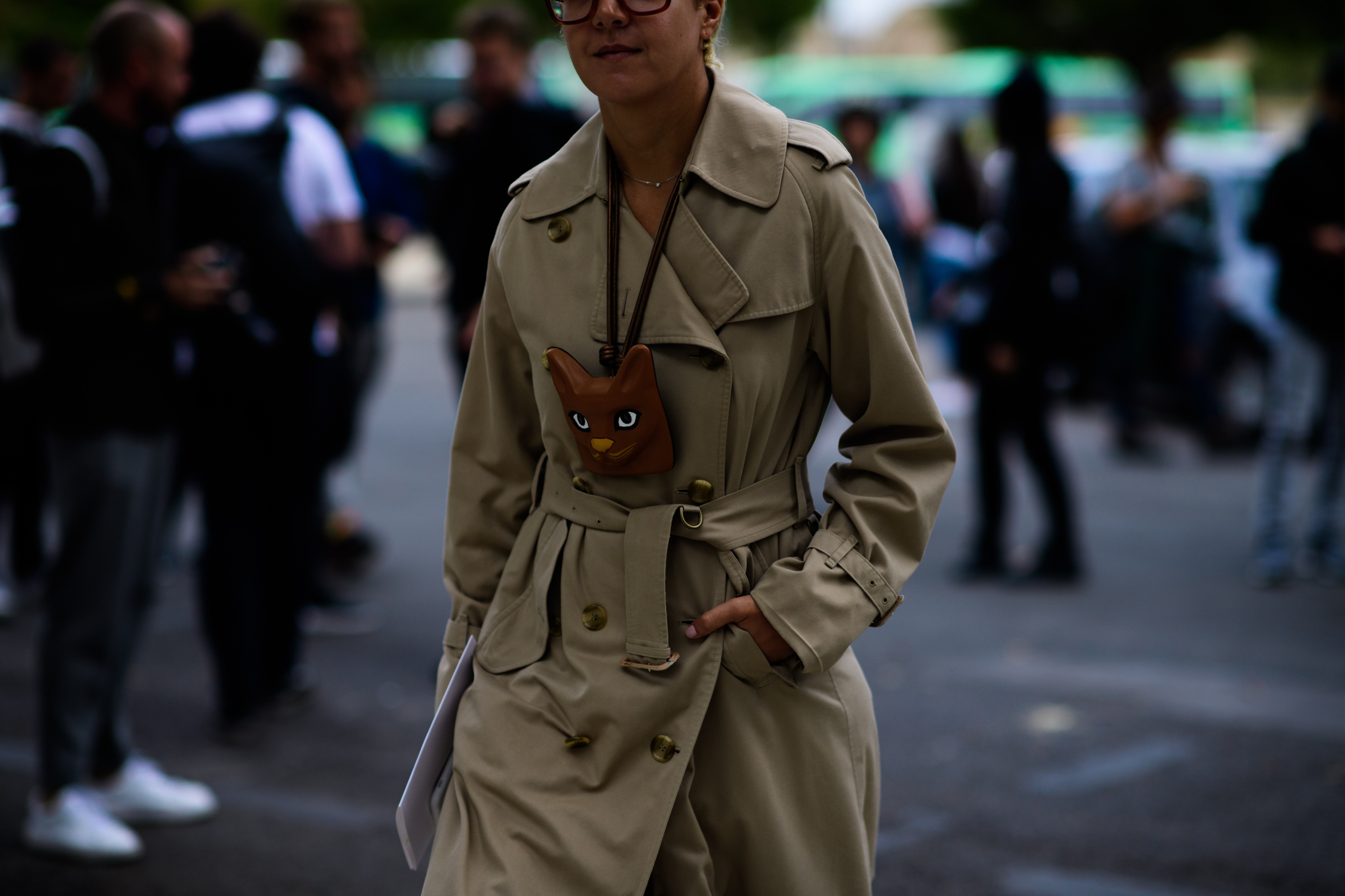 Woman wearing trench coat and brown animal bag
