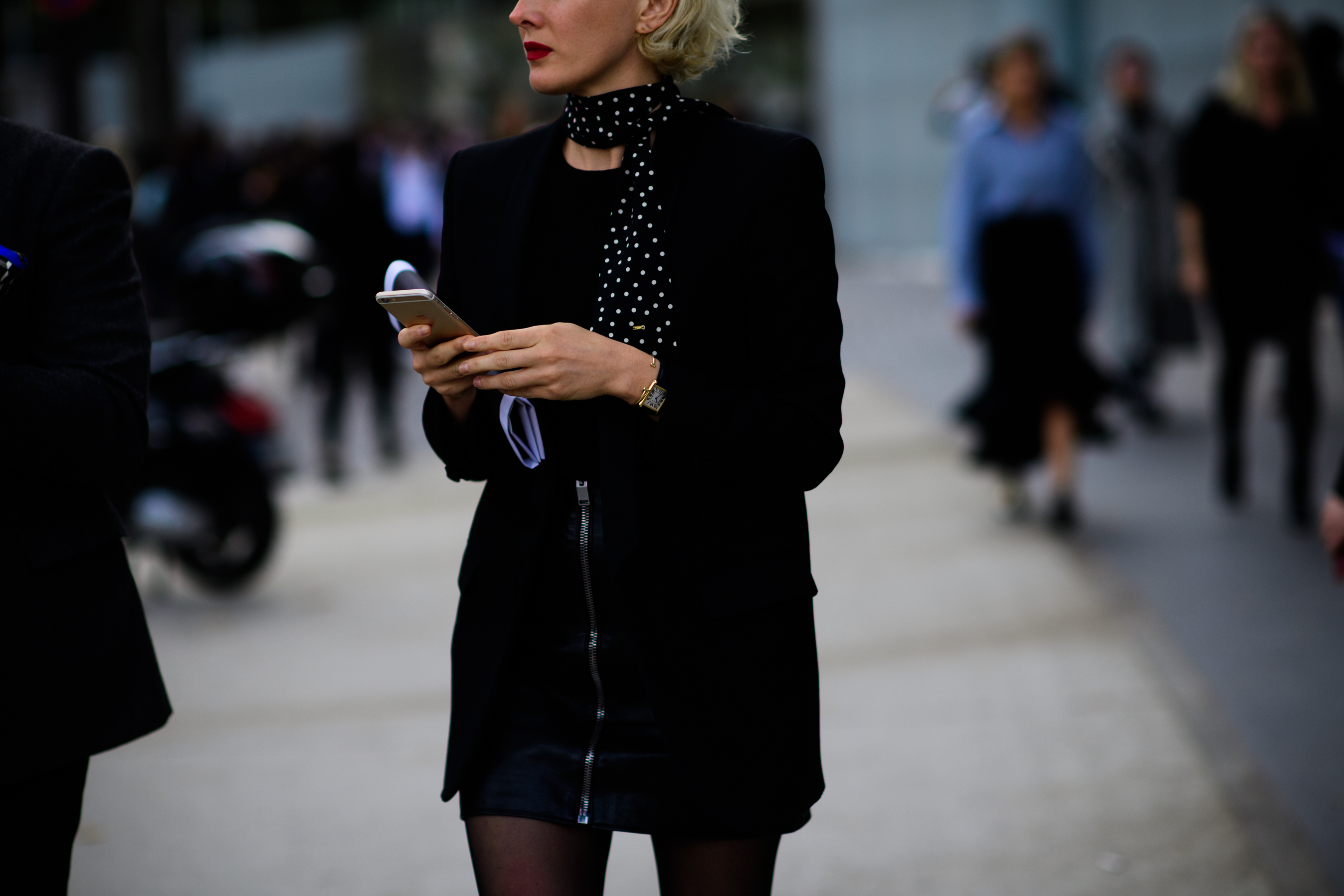 Woman in black jacket and skirt with spotted neckerchief