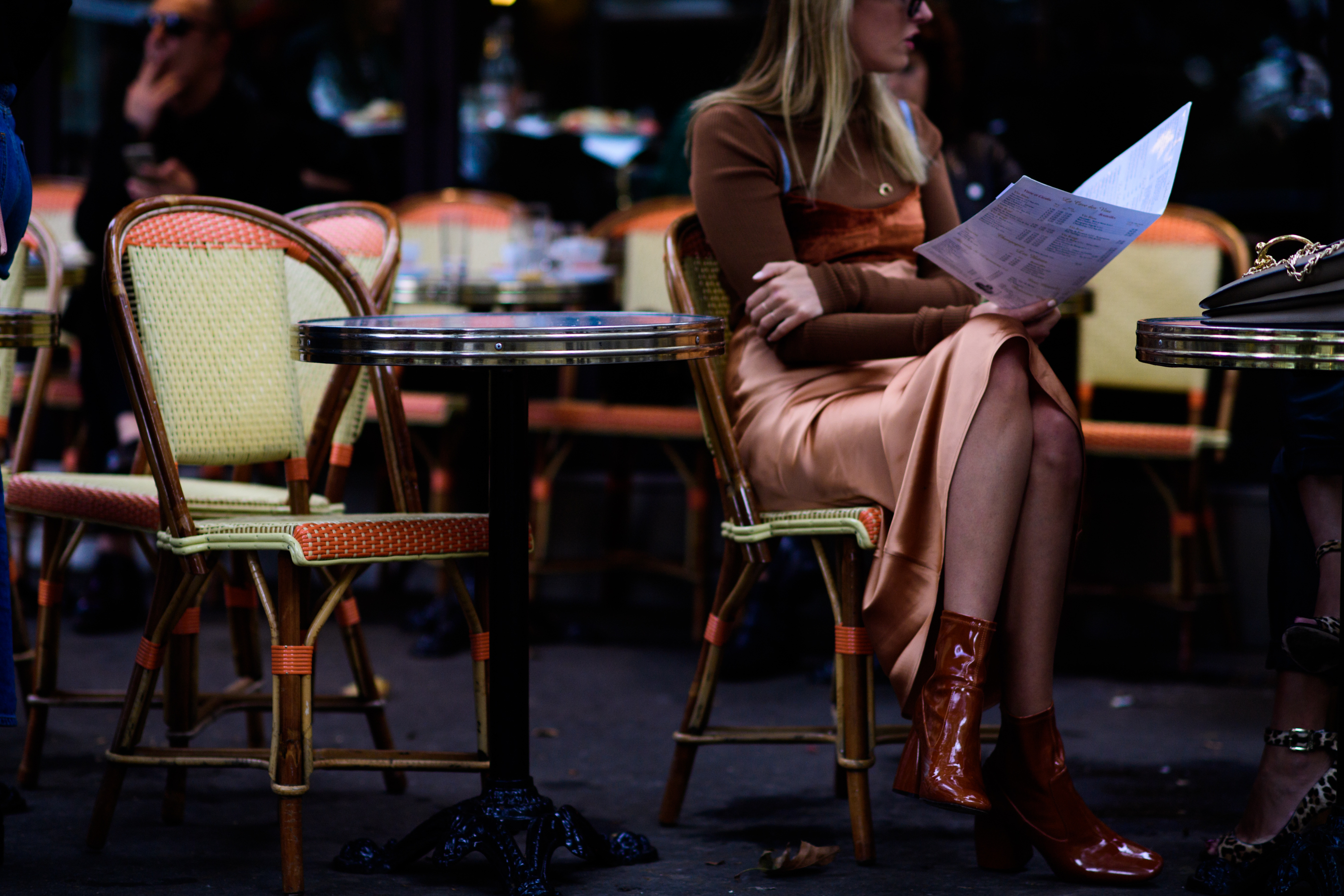 French blogger sat outside café reading menu